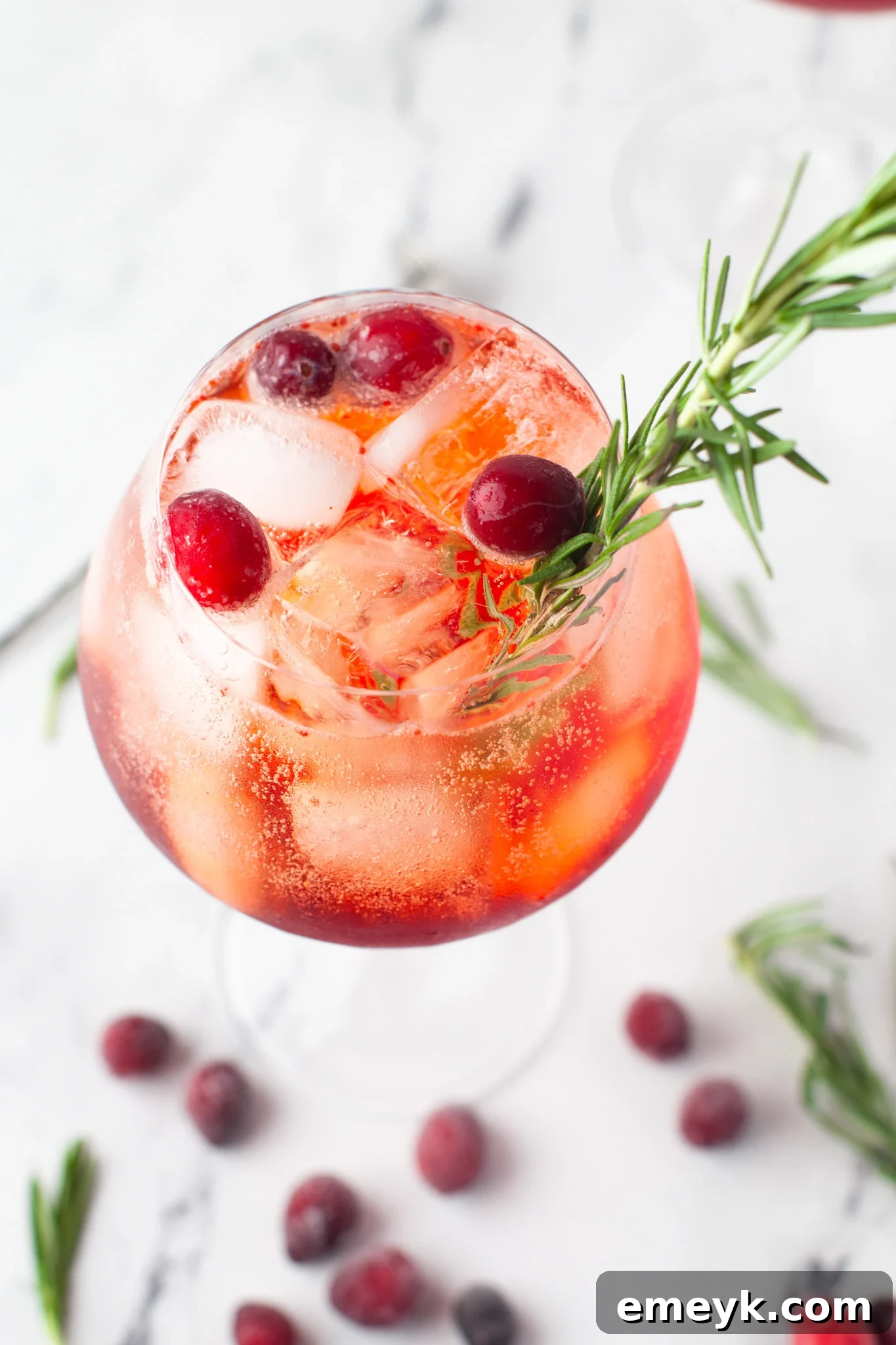 A beautifully composed Cranberry Aperol Spritz cocktail, adorned with a generous sprinkle of fresh cranberries, ready to be served.