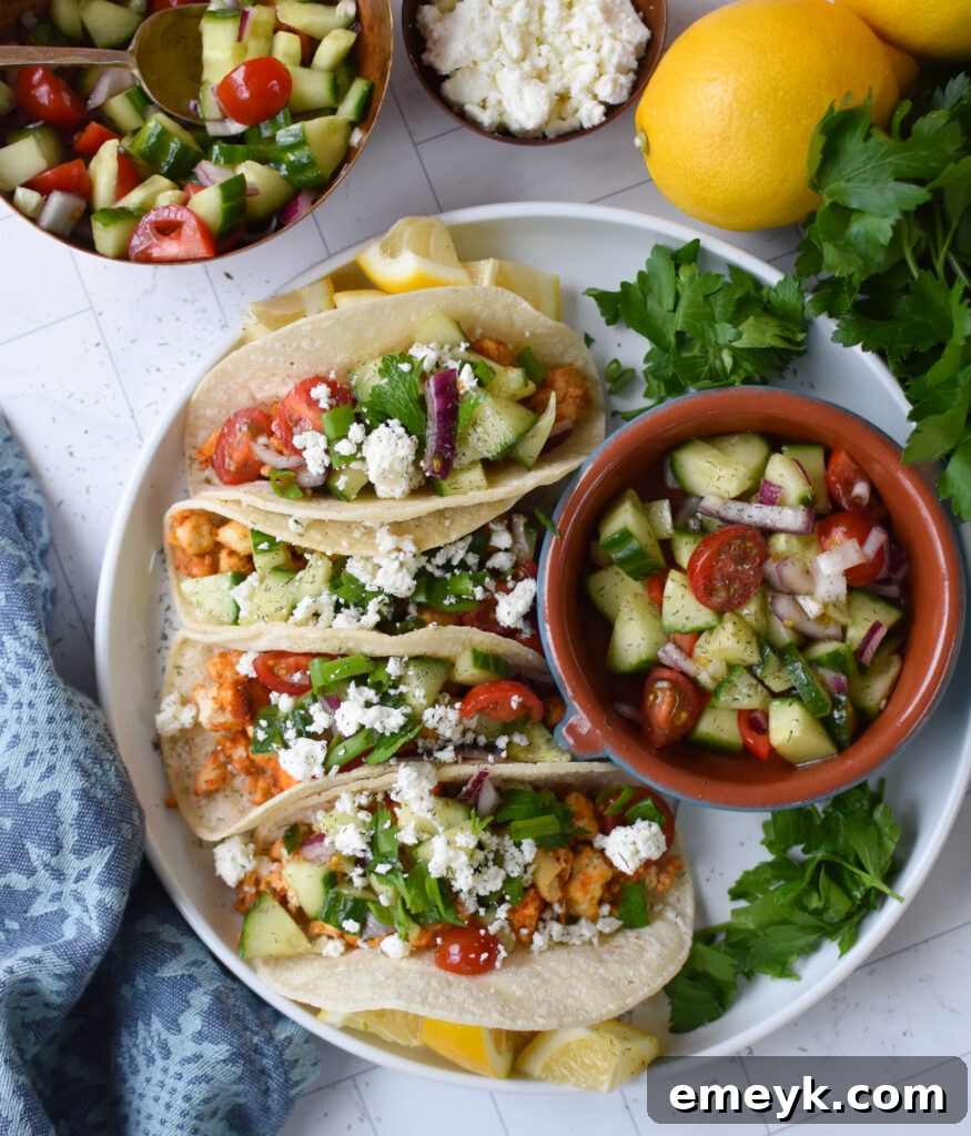 A hand topping a Mediterranean Style Tofu Taco with fresh salsa and herbs.