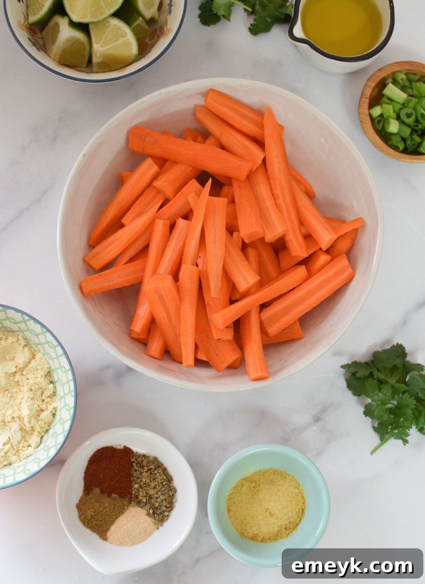 Golden Roasted Carrot Fries 3 Fresh carrots, chickpea flour, and spices laid out as ingredients for Oven Baked Carrot Fries.