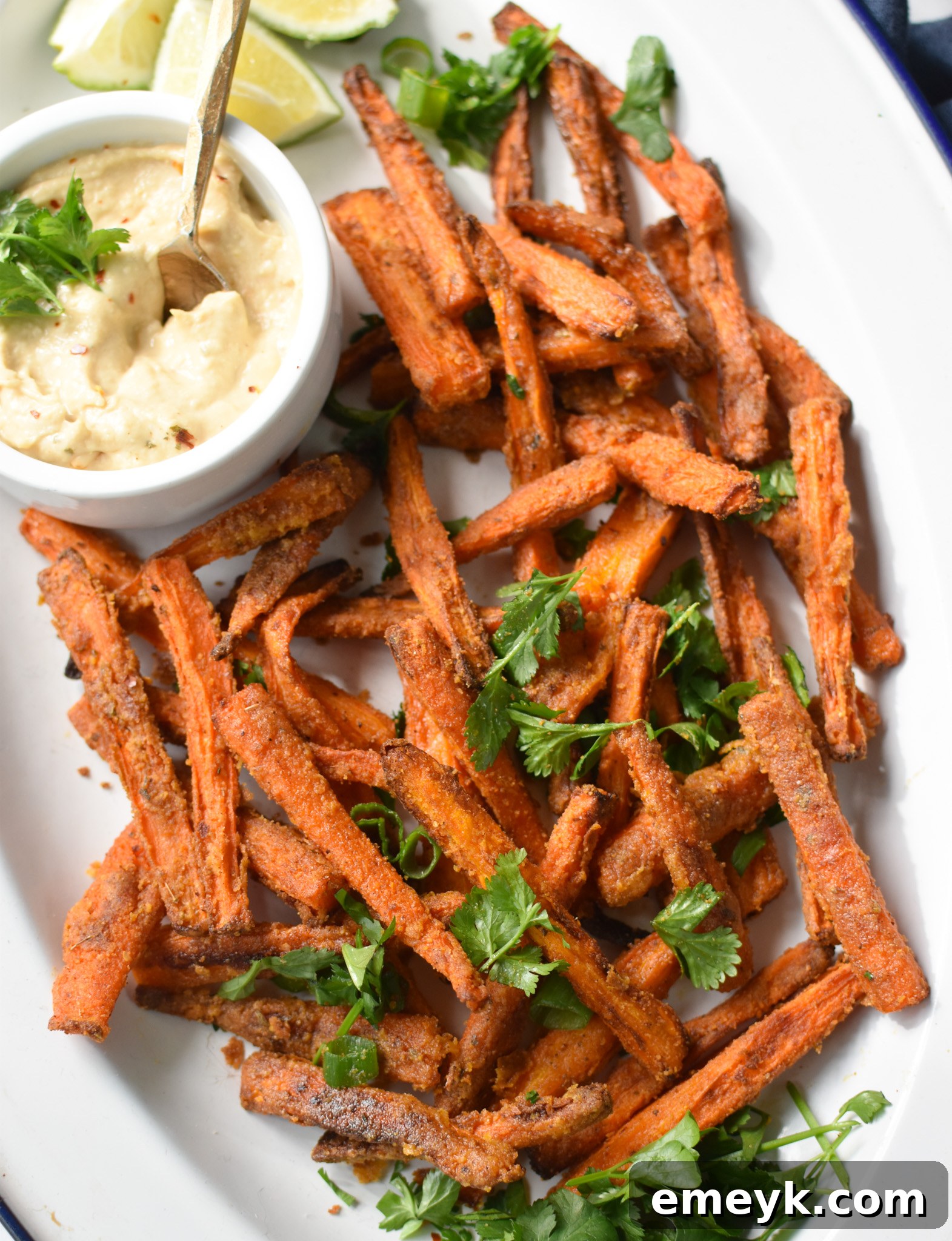 Golden Roasted Carrot Fries 4 Crispy Oven Baked Carrot Fries garnished with fresh parsley on a white plate, ready to be served.
