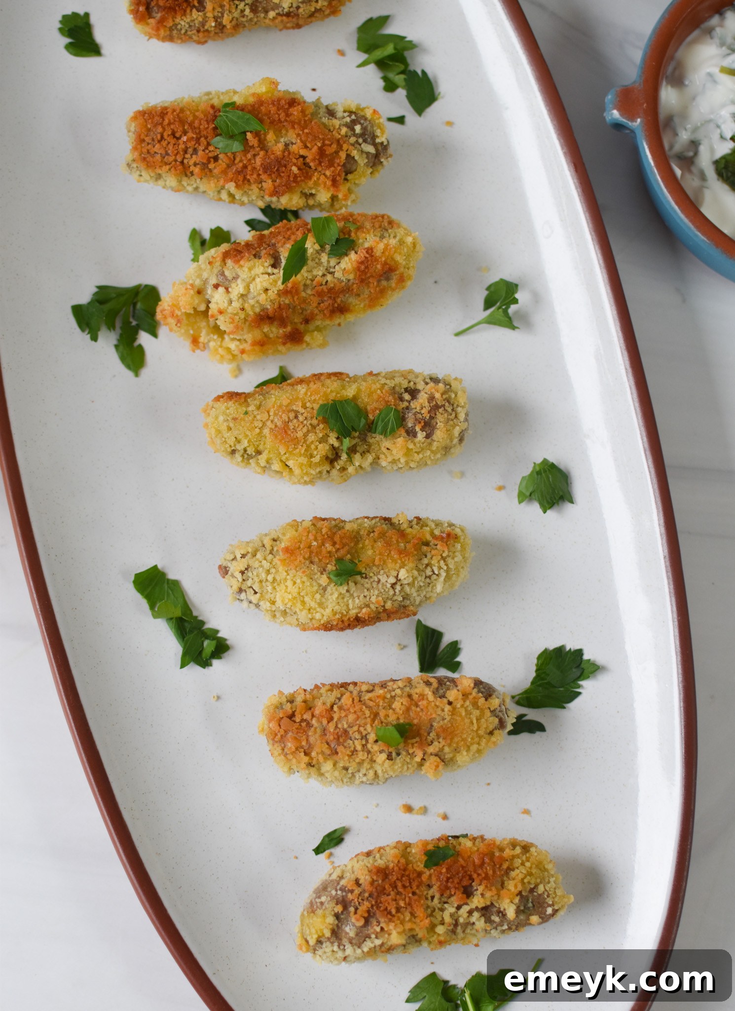 Gourmet Lamb Croquettes 5 A close-up of a lamb croquette garnished with fresh parsley, highlighting its crispy exterior.