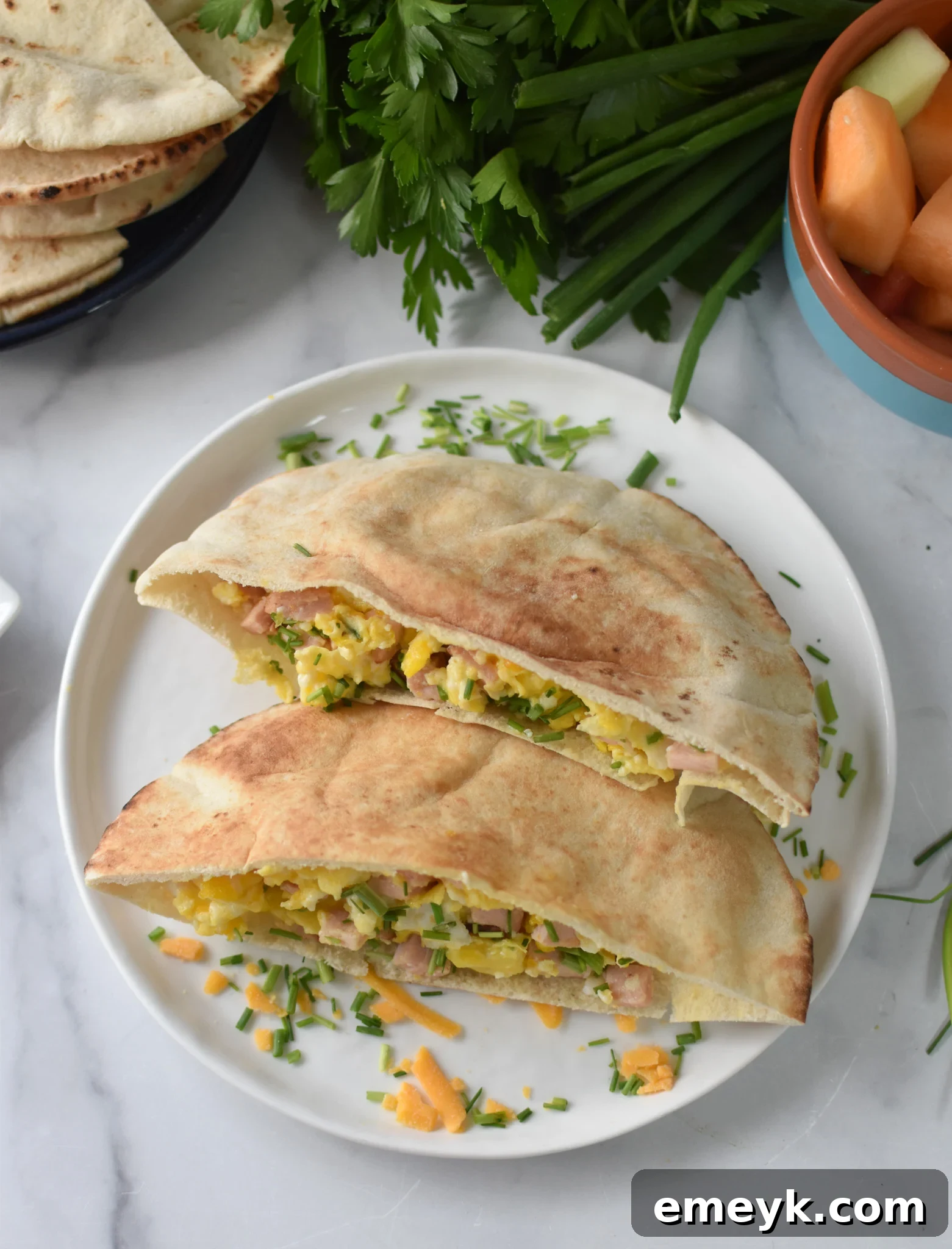 Sunrise Pita Pockets 4 A close-up of the Breakfast Pita Recipe, generously topped with fresh chives, highlighting its vibrant garnish.