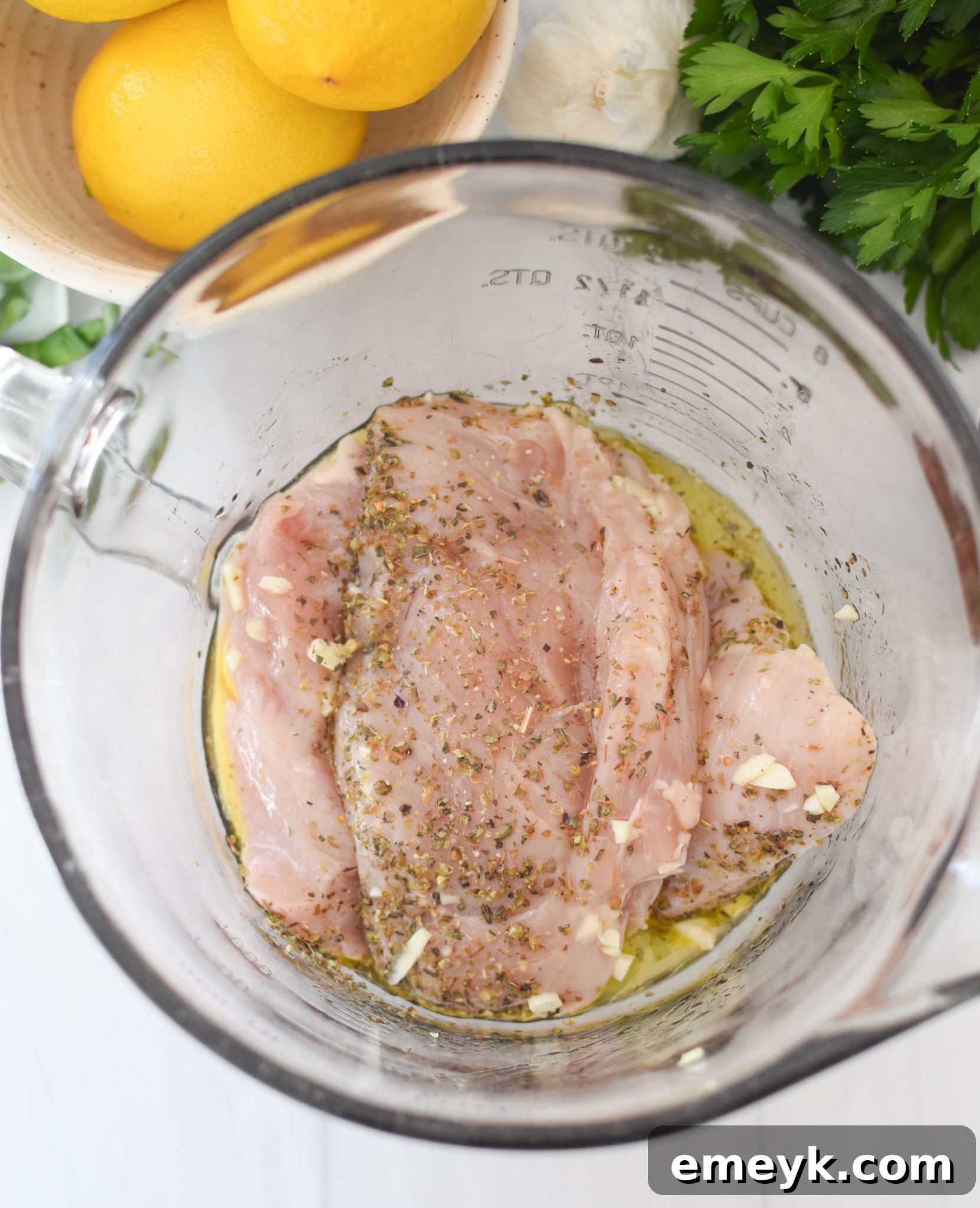 Chicken Bryan chicken soaking in a bowl with marinade, ready for grilling.