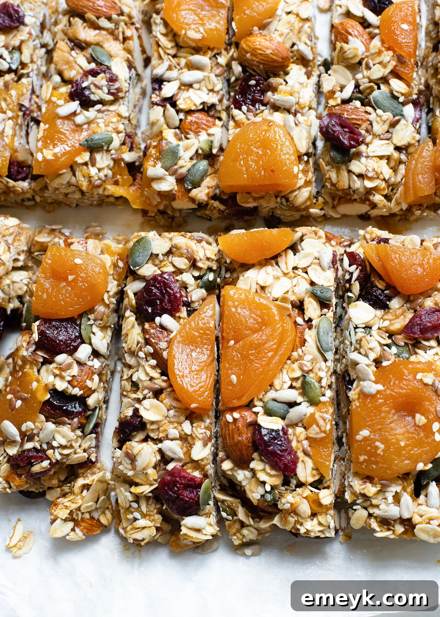 A stack of perfectly cut, ready-to-eat easy date granola bars, showcasing their wholesome layers of oats, nuts, and dried fruit, against a bright background.
