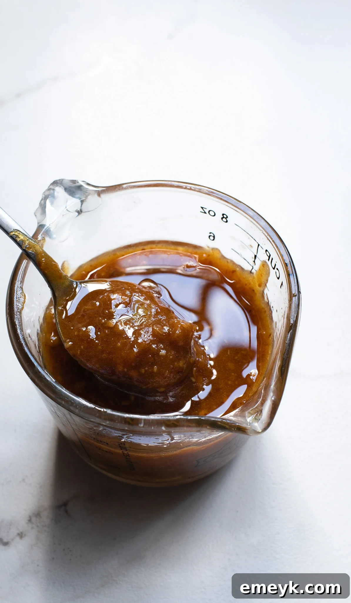 A close-up shot of the warm, amber-hued date paste mixture, smooth and ready to be combined with the dry ingredients for the granola bars.