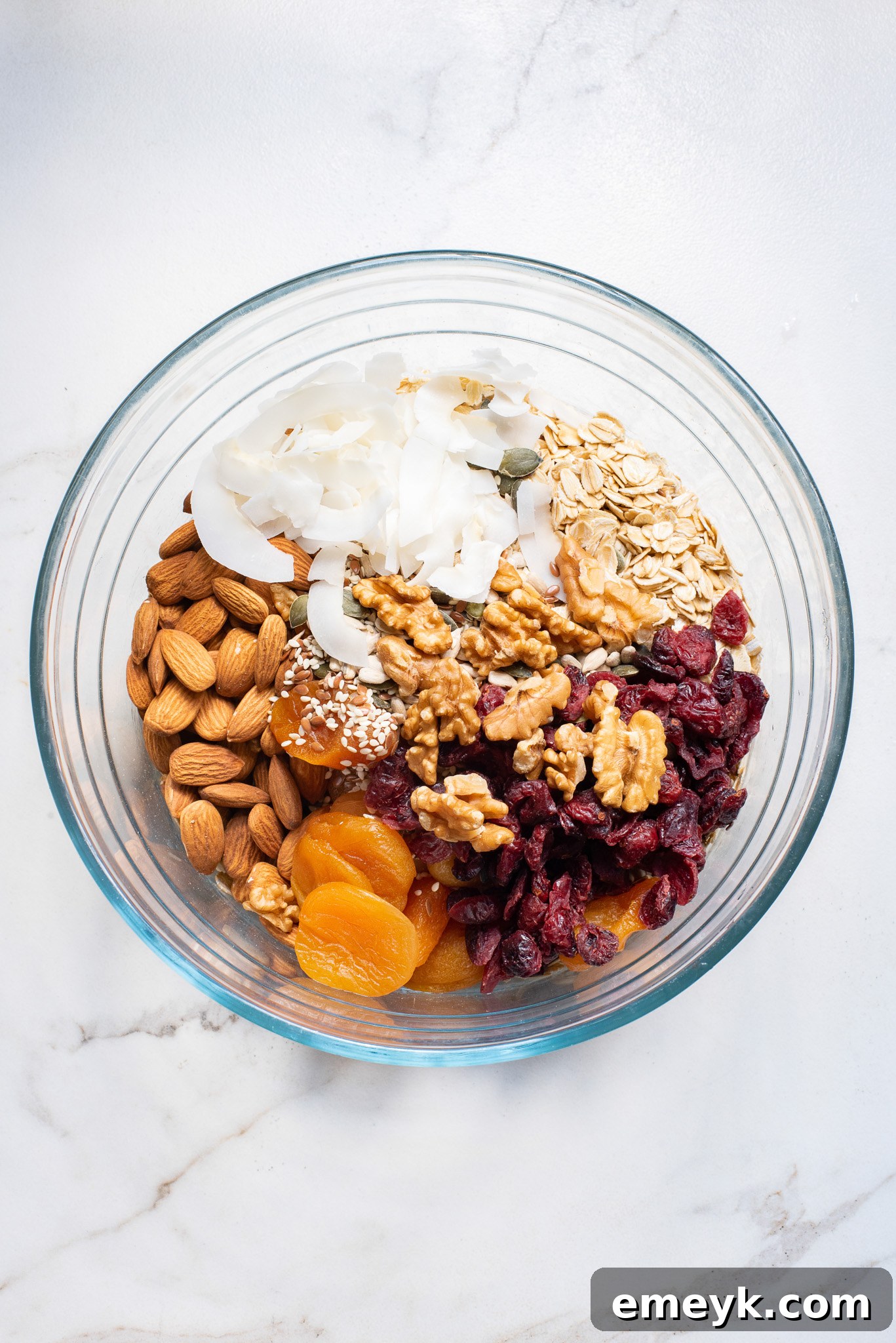 The dry ingredients for the granola bars—oats, dried fruits, nuts, and seeds—are perfectly mixed in a large bowl, awaiting the wet binder.