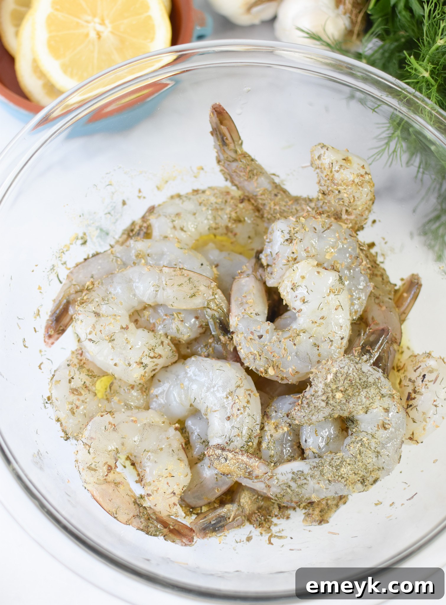 Greek Shrimp Marinade shrimp marinating in a bowl. 