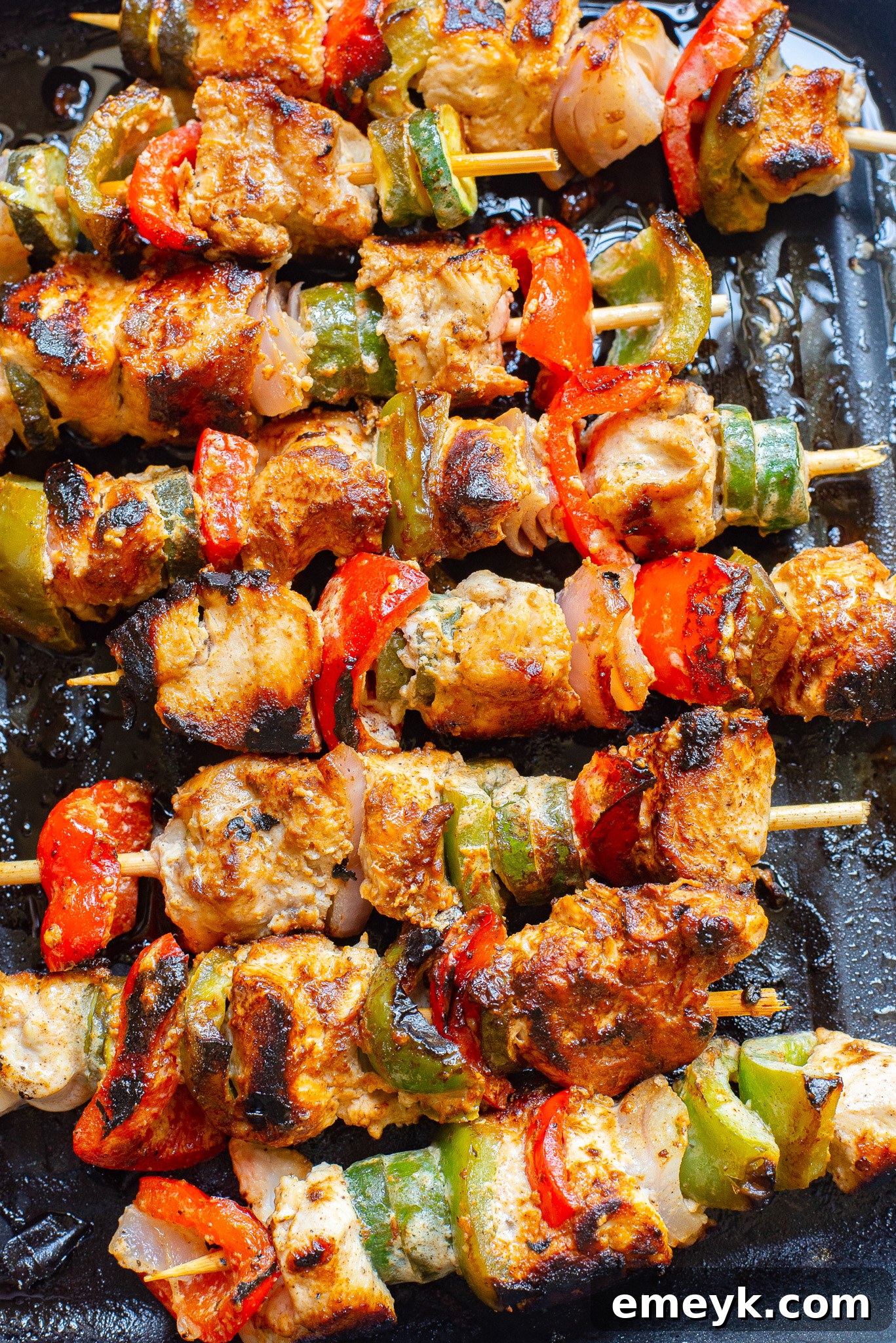 Lemon-Herb Mediterranean Chicken Skewers 4 Greek Marinated Chicken Kabobs with Lemon cooking on an outdoor grill.