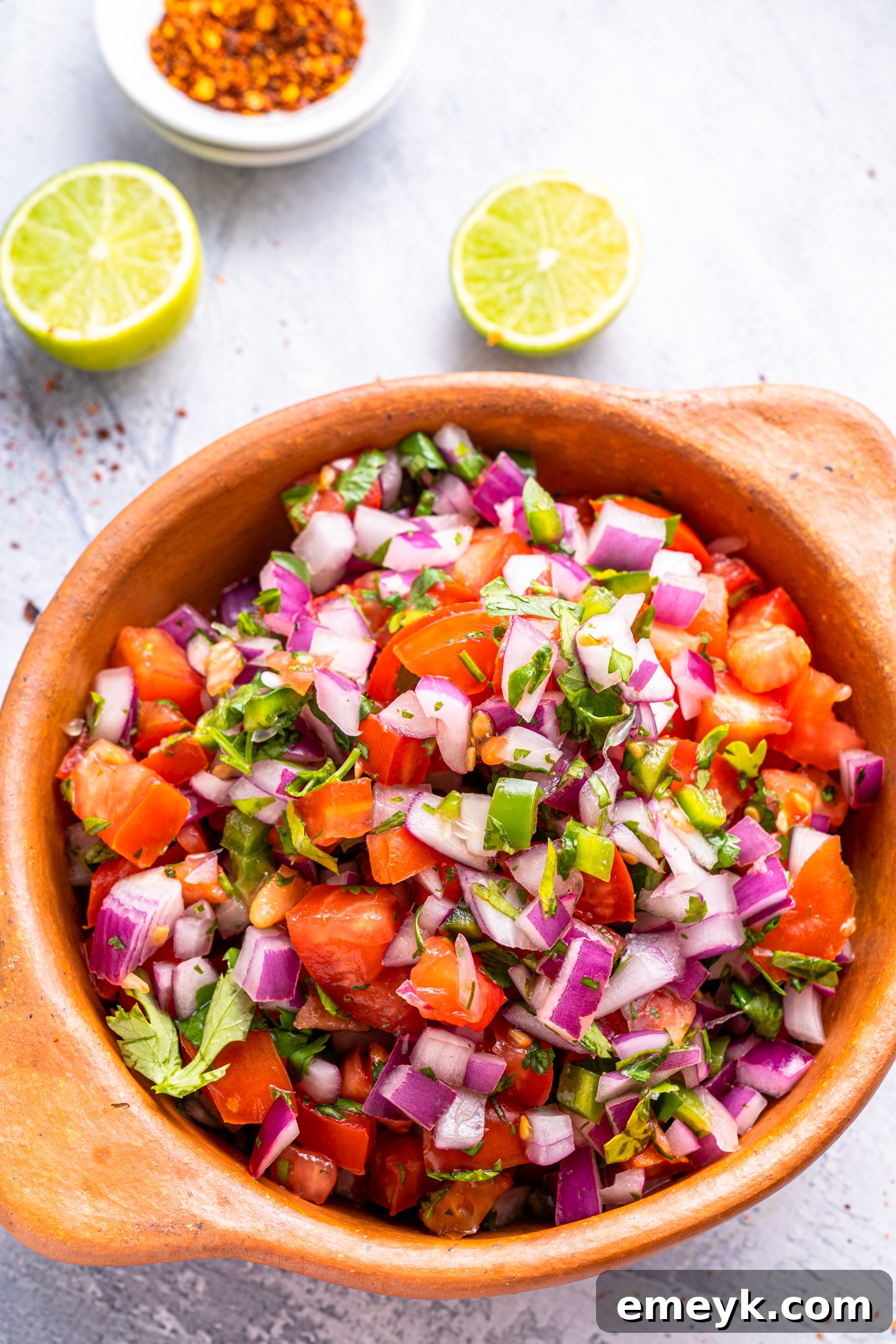A bowl of vibrant homemade Pico de Gallo, featuring diced tomatoes, red onion, jalapeño, and cilantro.