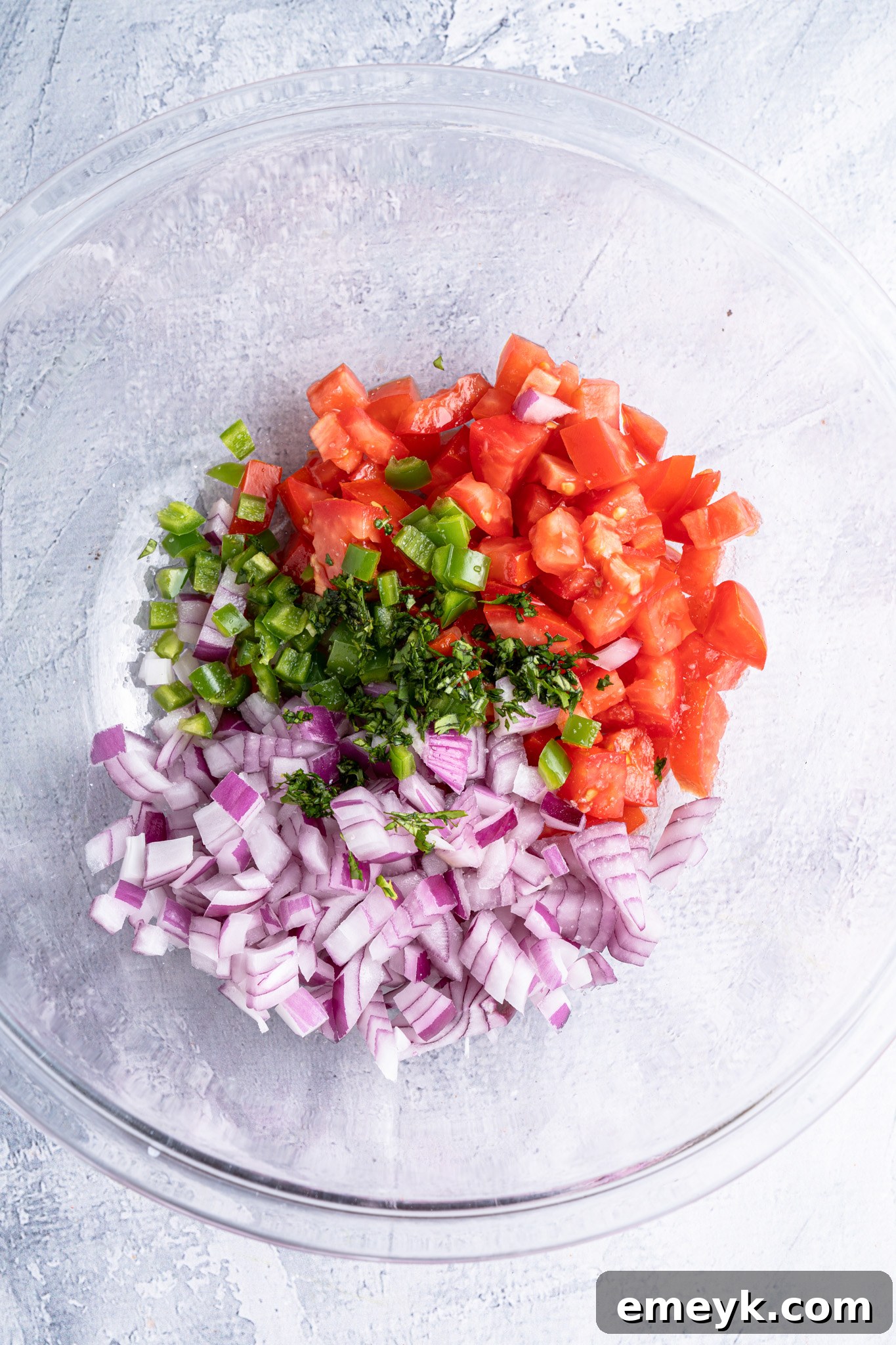 All the diced ingredients for Homemade Pico de Gallo mixed in a large bowl, ready to be seasoned.