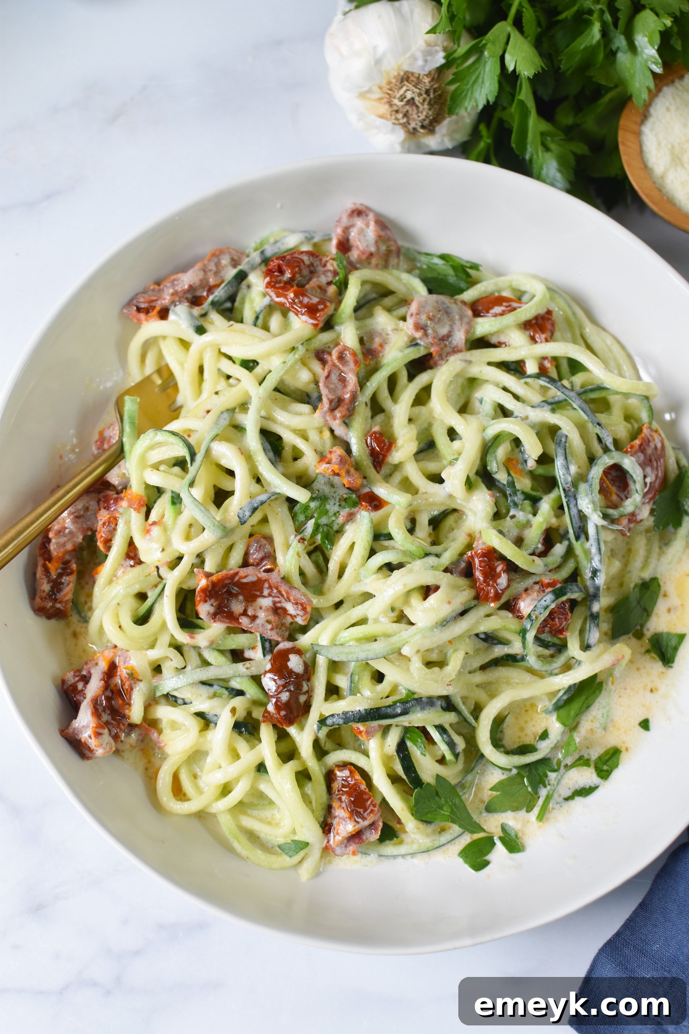 Creamy Zucchini Noodle Alfredo 4 A serving of Alfredo Zoodles Recipe in a white bowl, garnished and ready to enjoy.