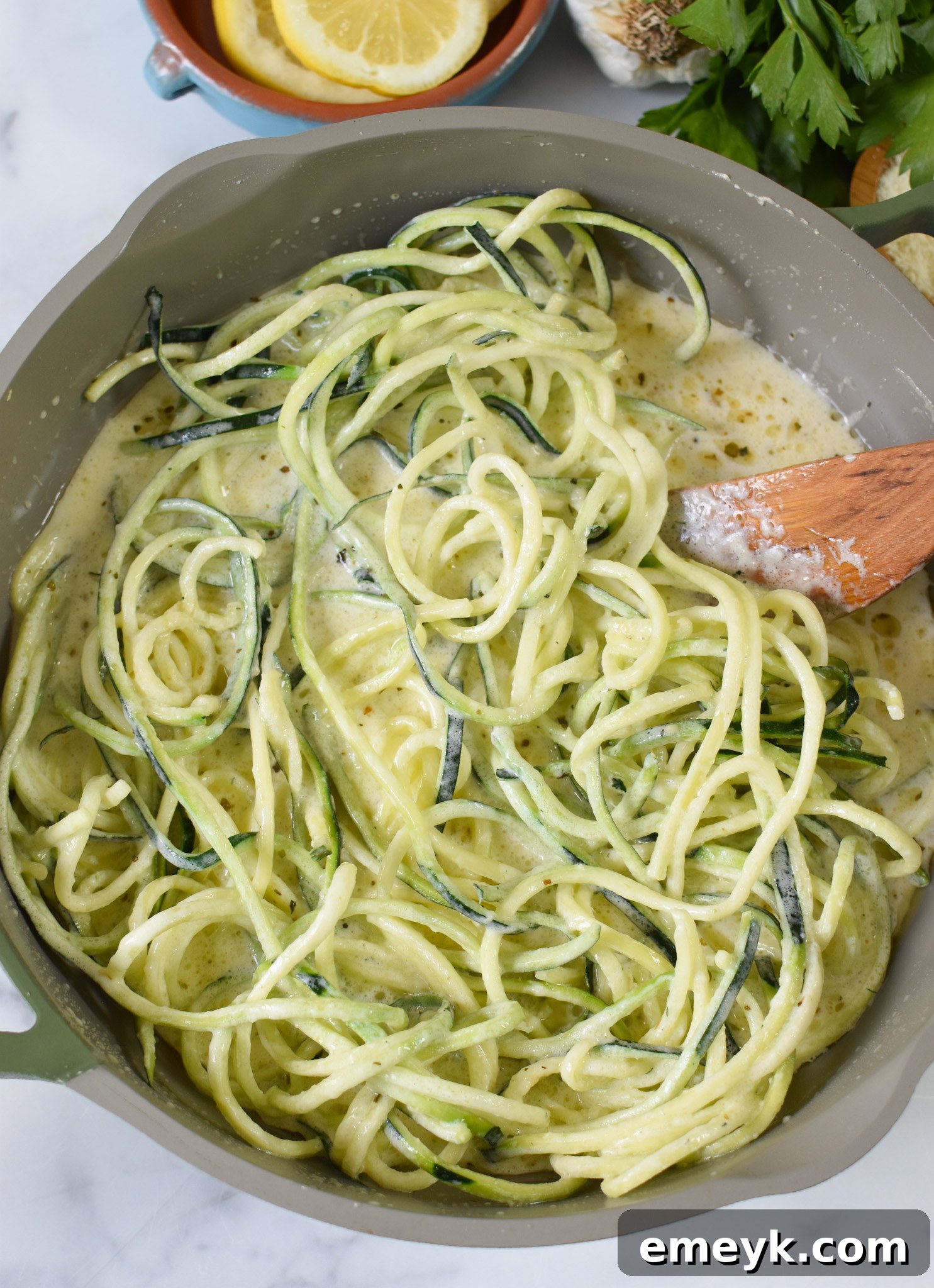 Creamy Zucchini Noodle Alfredo 6 Alfredo Zoodles in a skillet, showing the zucchini noodles coated in creamy sauce with sun-dried tomatoes.