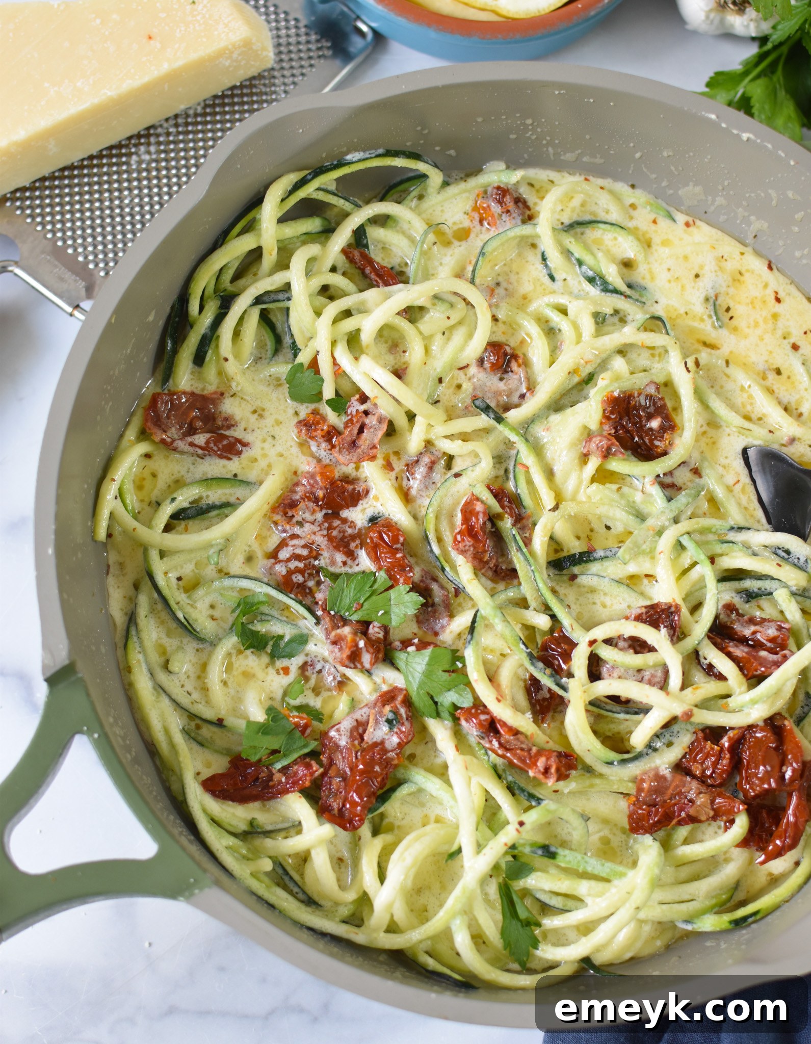 Creamy Zucchini Noodle Alfredo 7 Close-up of Alfredo Zoodles cooking in a pan, highlighting the vibrant colors and creamy texture.