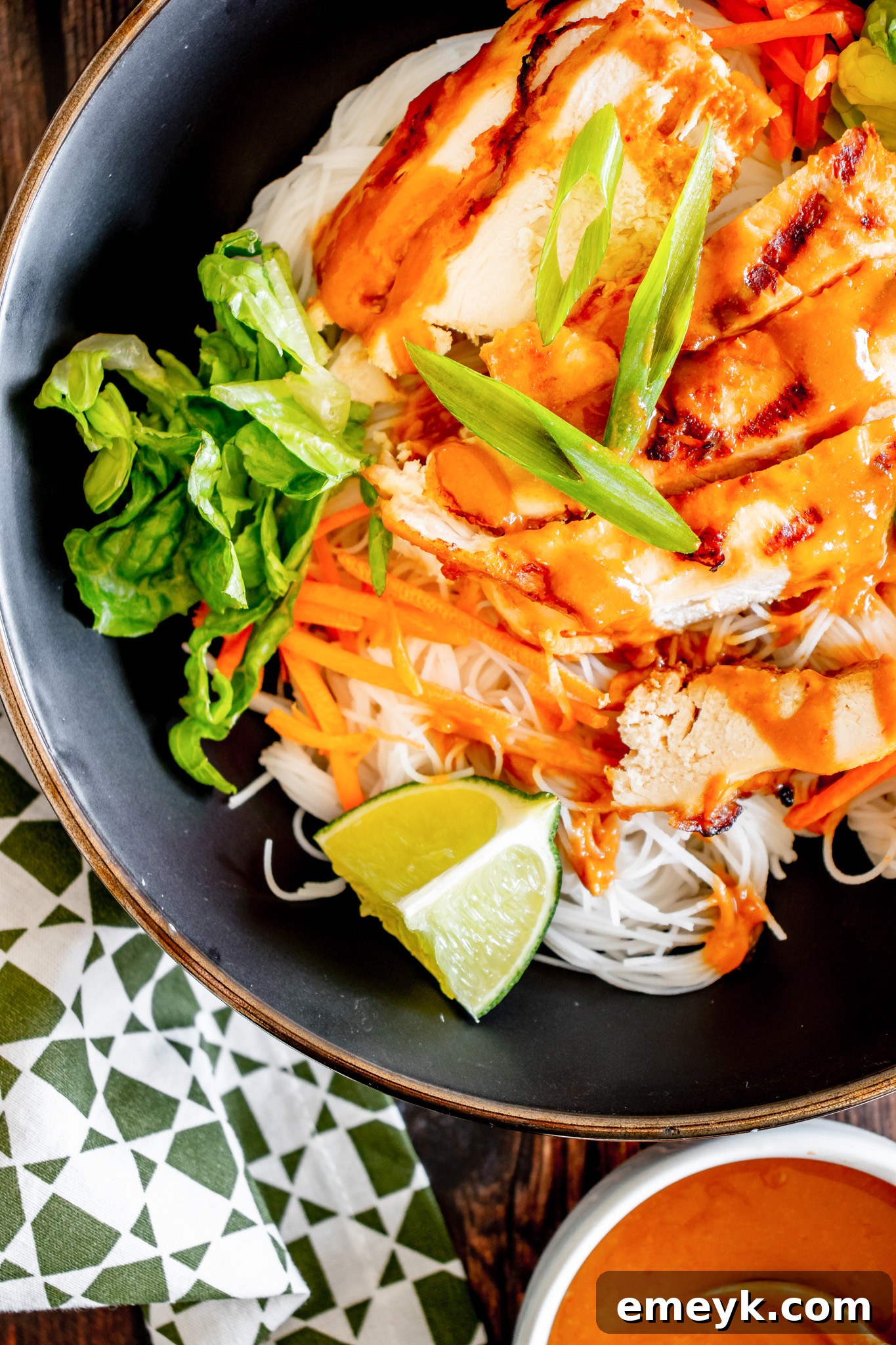 Thai Chicken Noodle Salad served in a stylish black bowl, showcasing its rich colors and textures.
