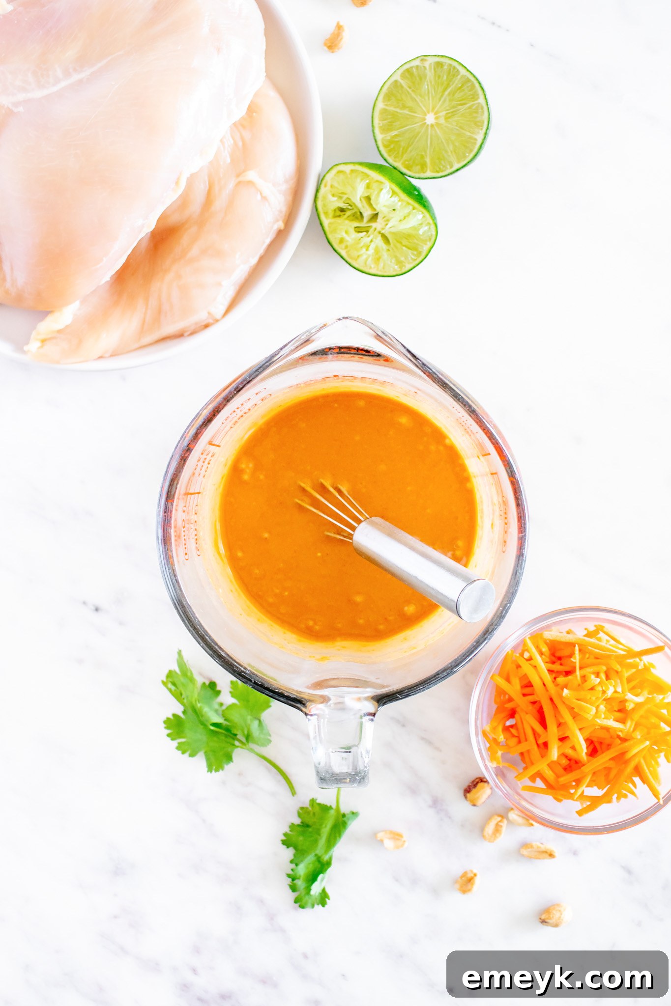 Chicken breasts soaking in the rich Thai marinade in a bowl.