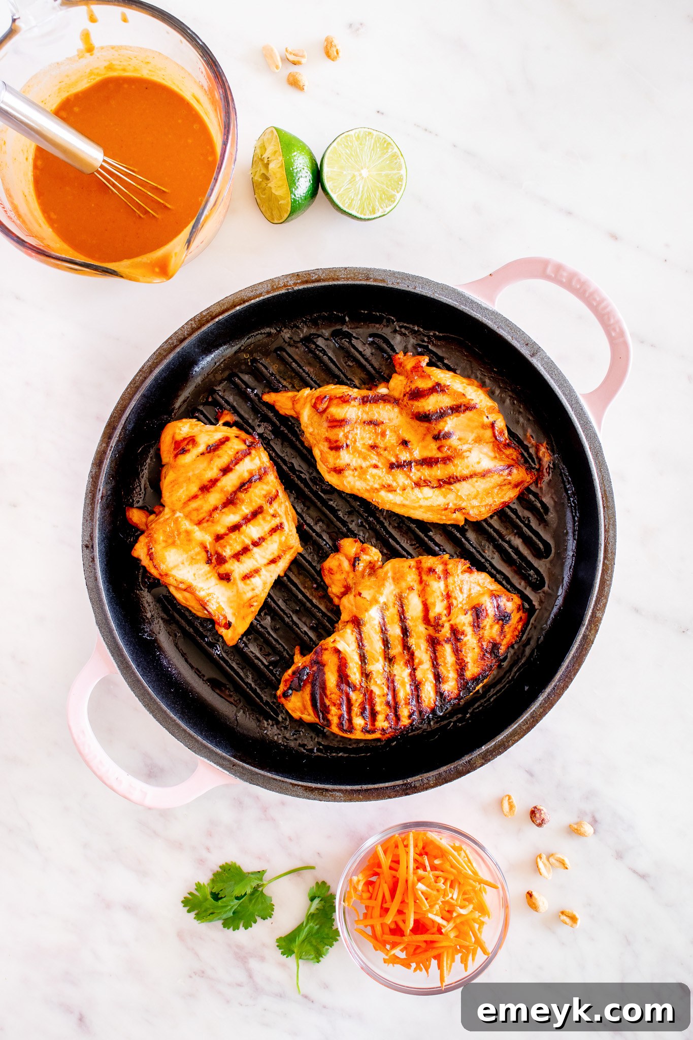Sliced grilled chicken resting on a cutting board, ready to be added to the salad.