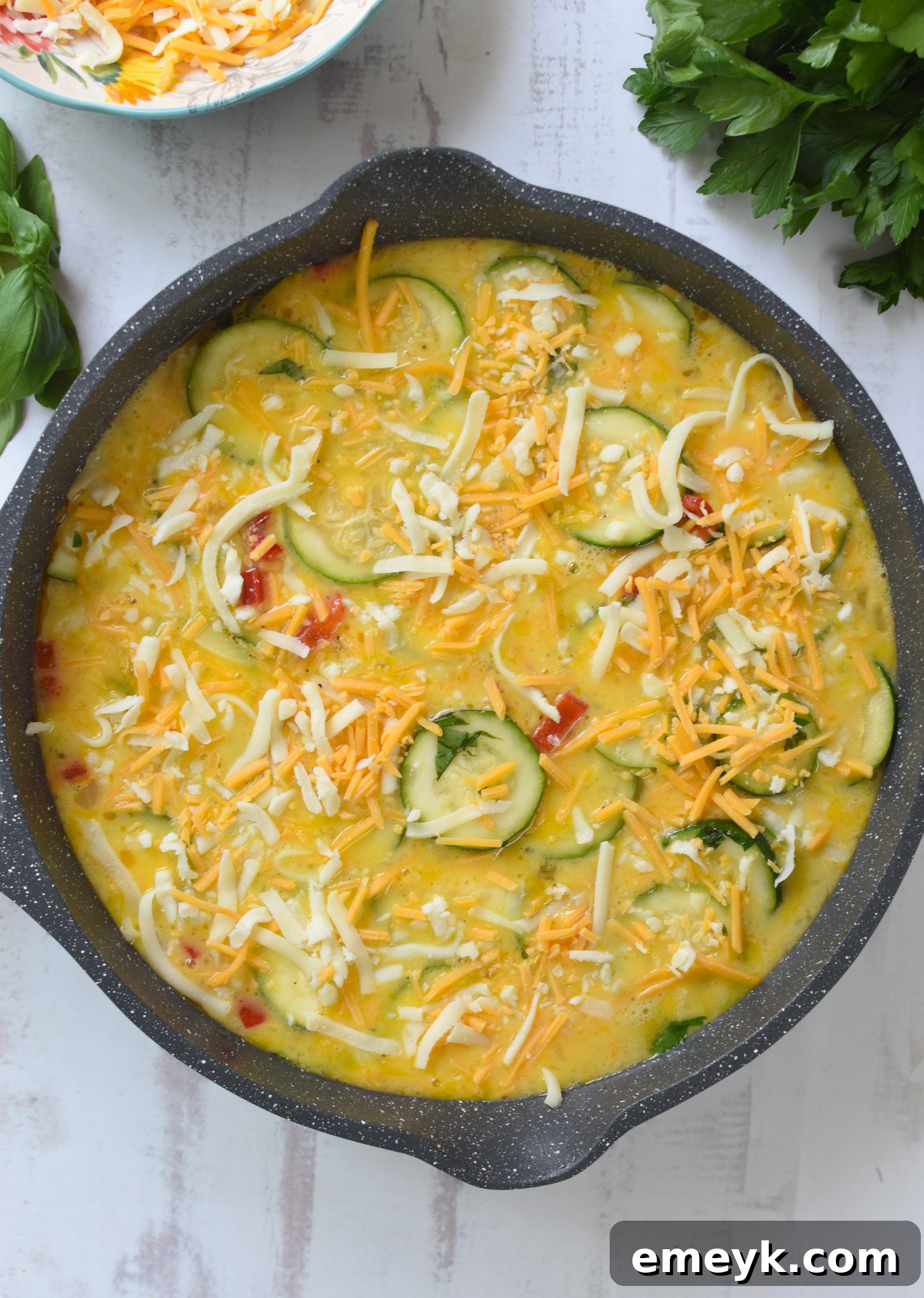 Zucchini Frittata Recipe with a final layer of cheese on the eggs.
