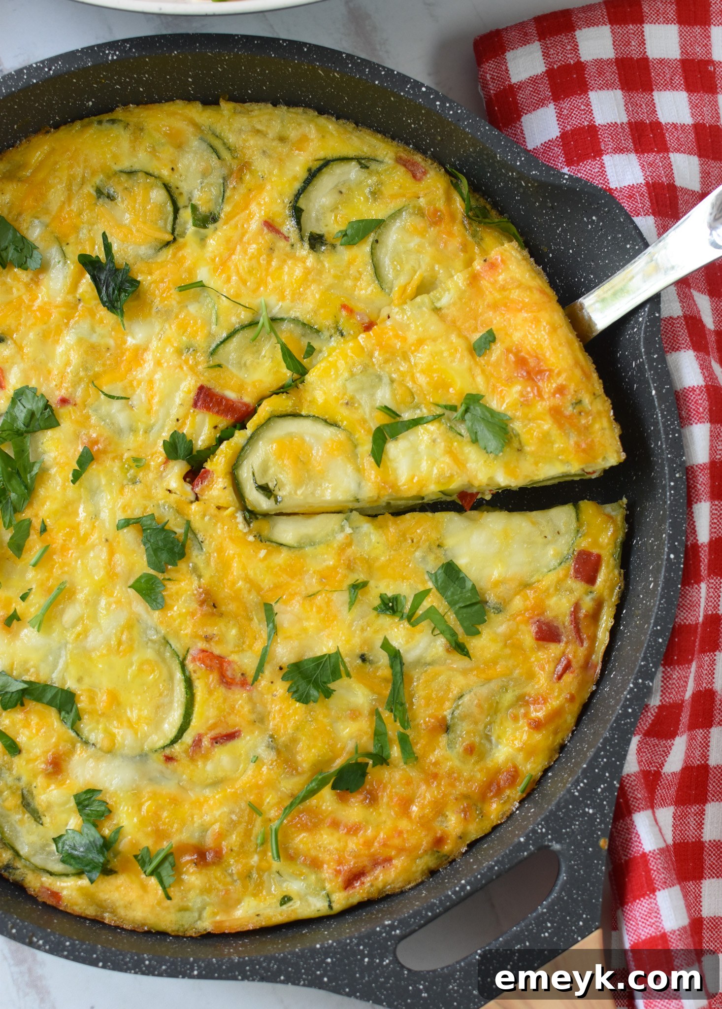 Zucchini Frittata Recipe being cut with a pie cutter.