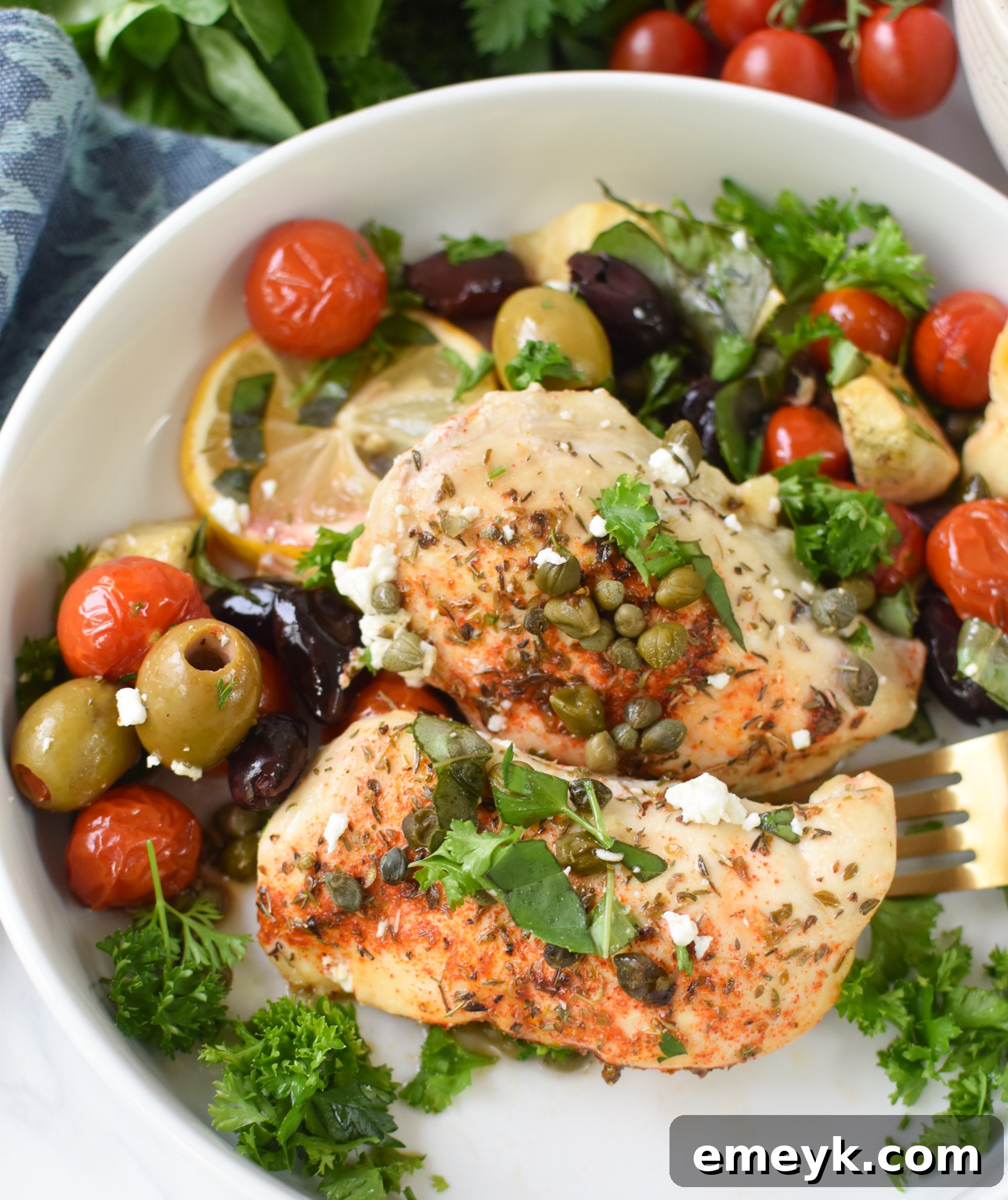 A serving of Mediterranean Skillet Chicken presented beautifully in a white bowl, garnished with fresh herbs and a lemon wedge.