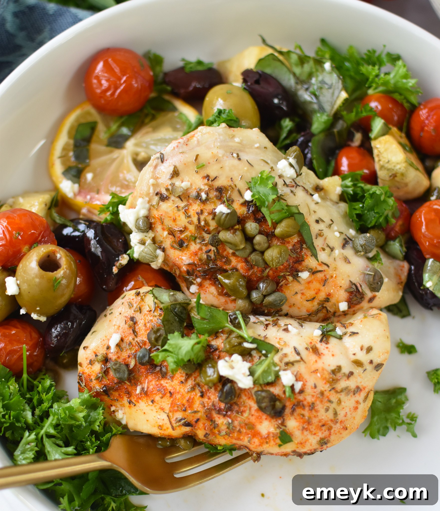 Mediterranean Skillet Chicken baked to perfection in a skillet, garnished with an abundance of fresh parsley and basil.