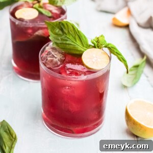 Two glasses of Vodka Cherry Limeade with garnishes.
