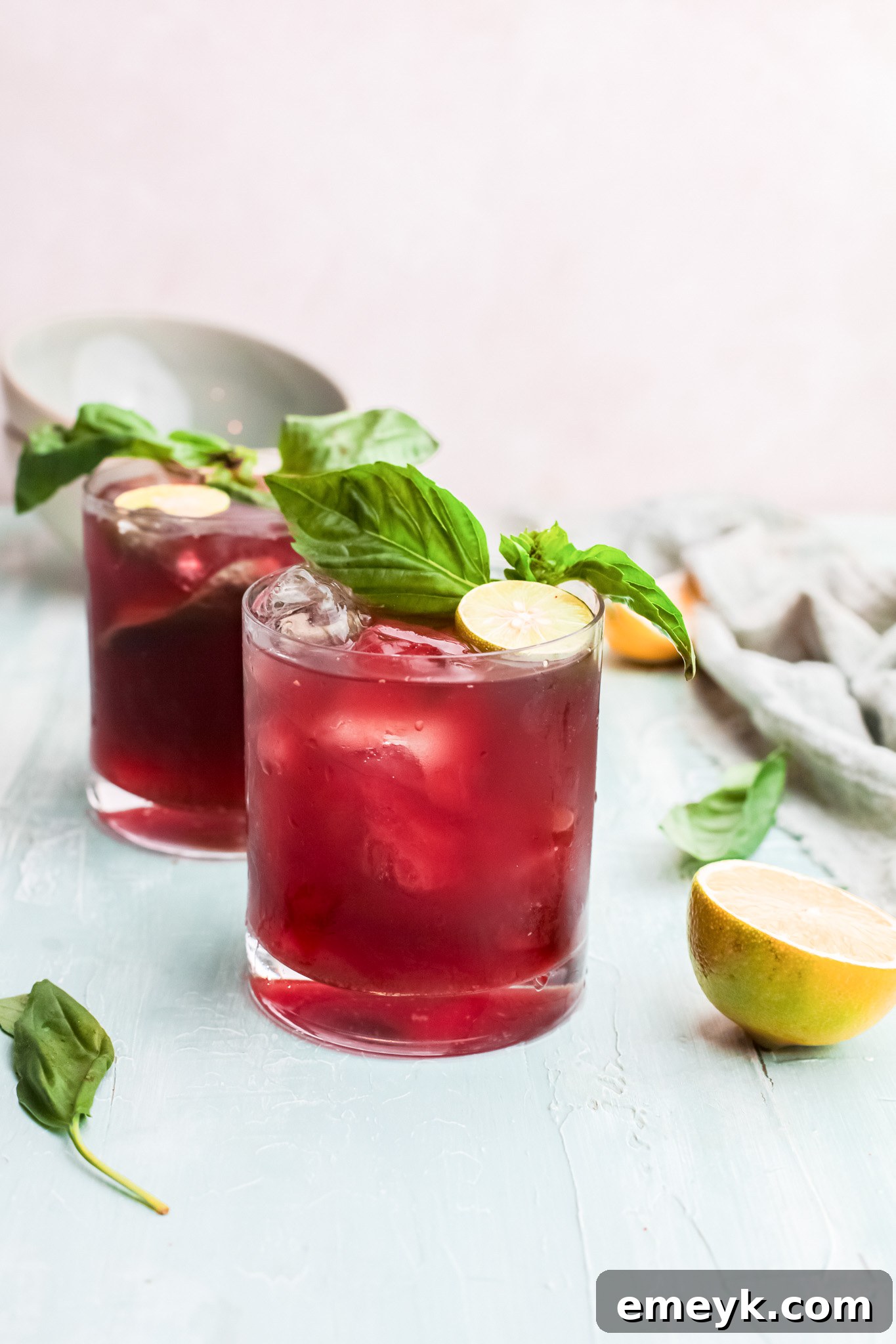 A glass of Vodka Cherry Limeade with fresh lime slices and ice.
