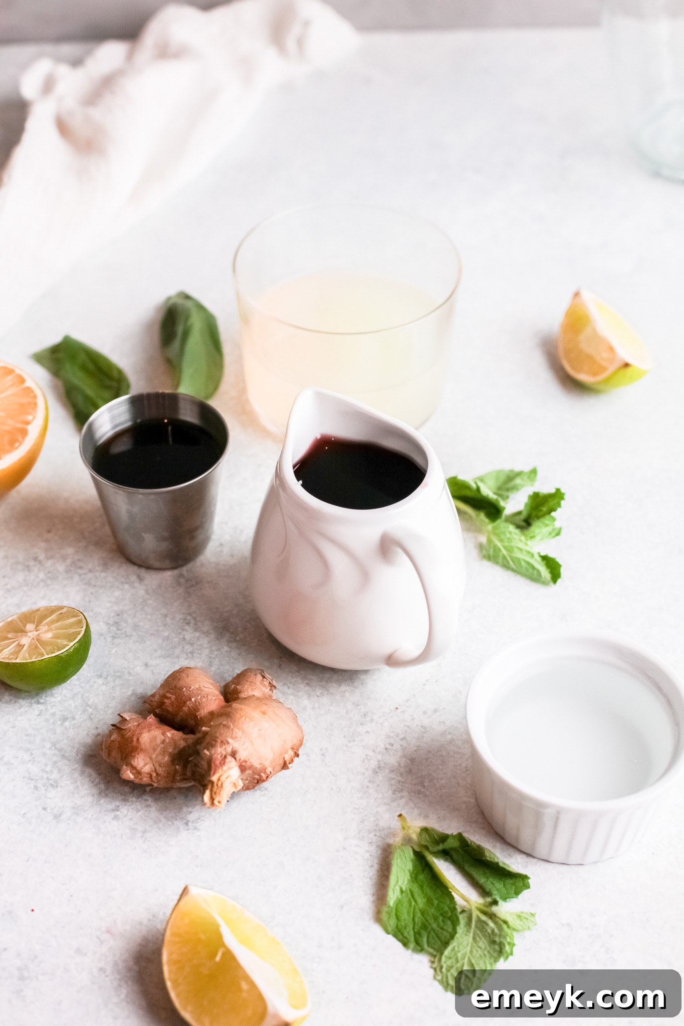 Ingredients for Vodka Cherry Limeade laid out: cherry juice, lime juice, vodka, honey, mint, ginger.