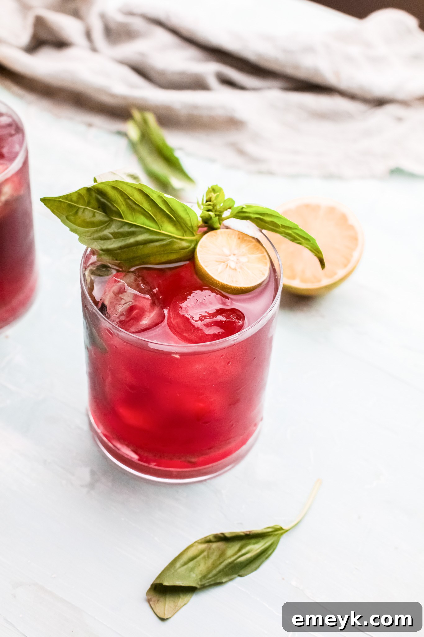 Preparing a glass for Vodka Cherry Limeade, showing fresh mint leaves and grated ginger.
