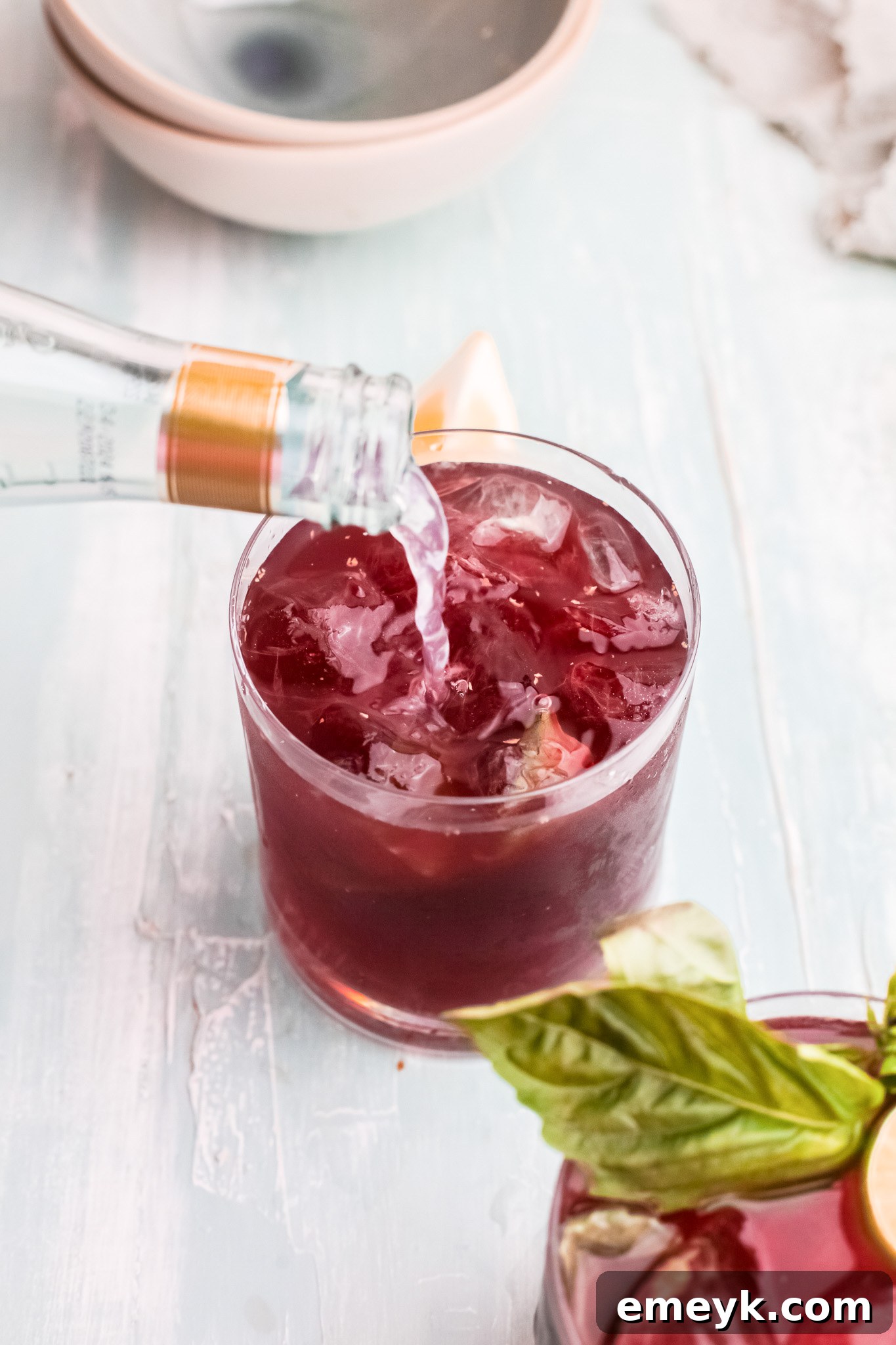 Lemon-lime soda being poured into a glass of Vodka Cherry Limeade.