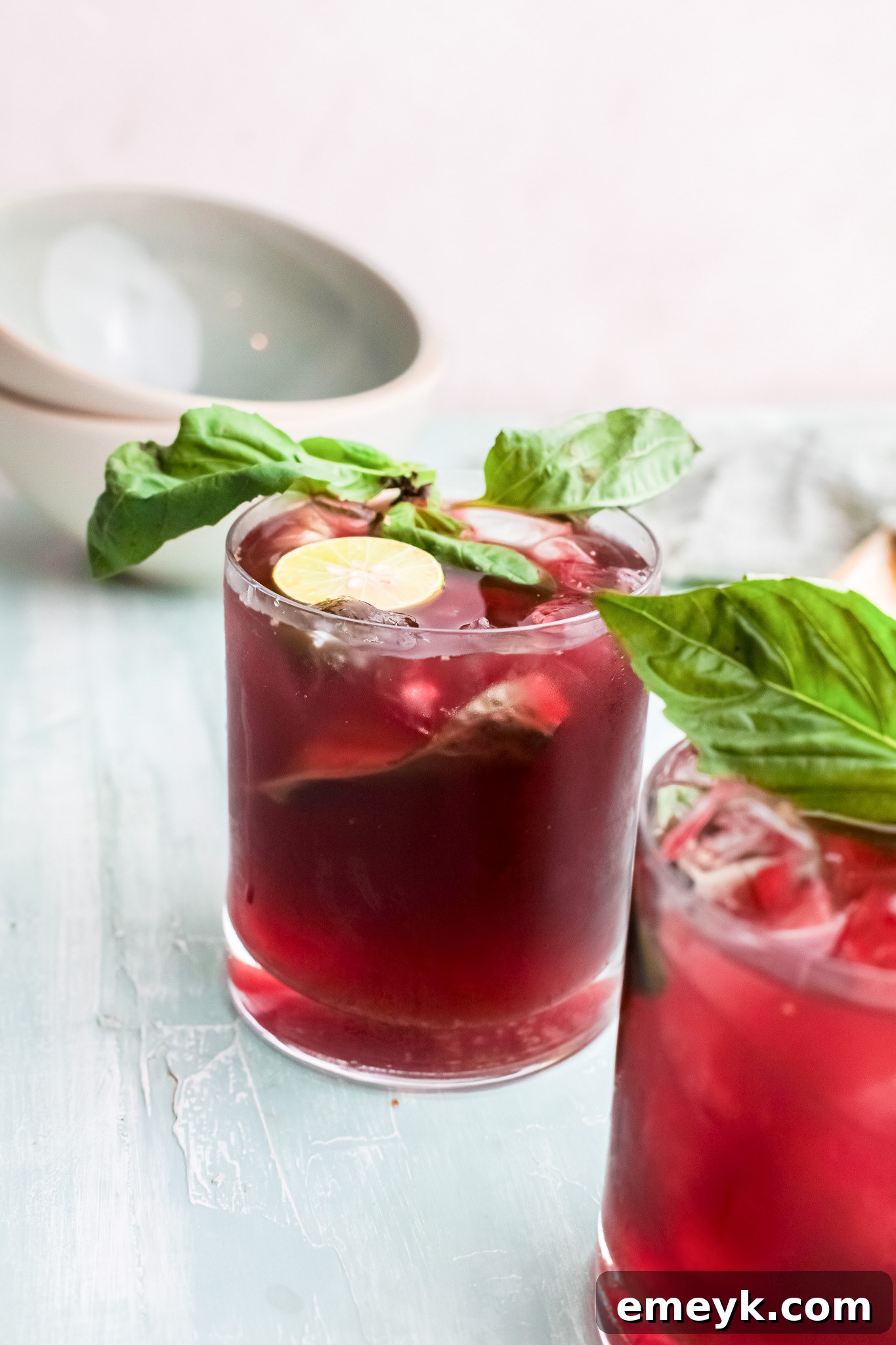 A vibrant glass of Vodka Cherry Limeade, garnished with lime, ready to be enjoyed.