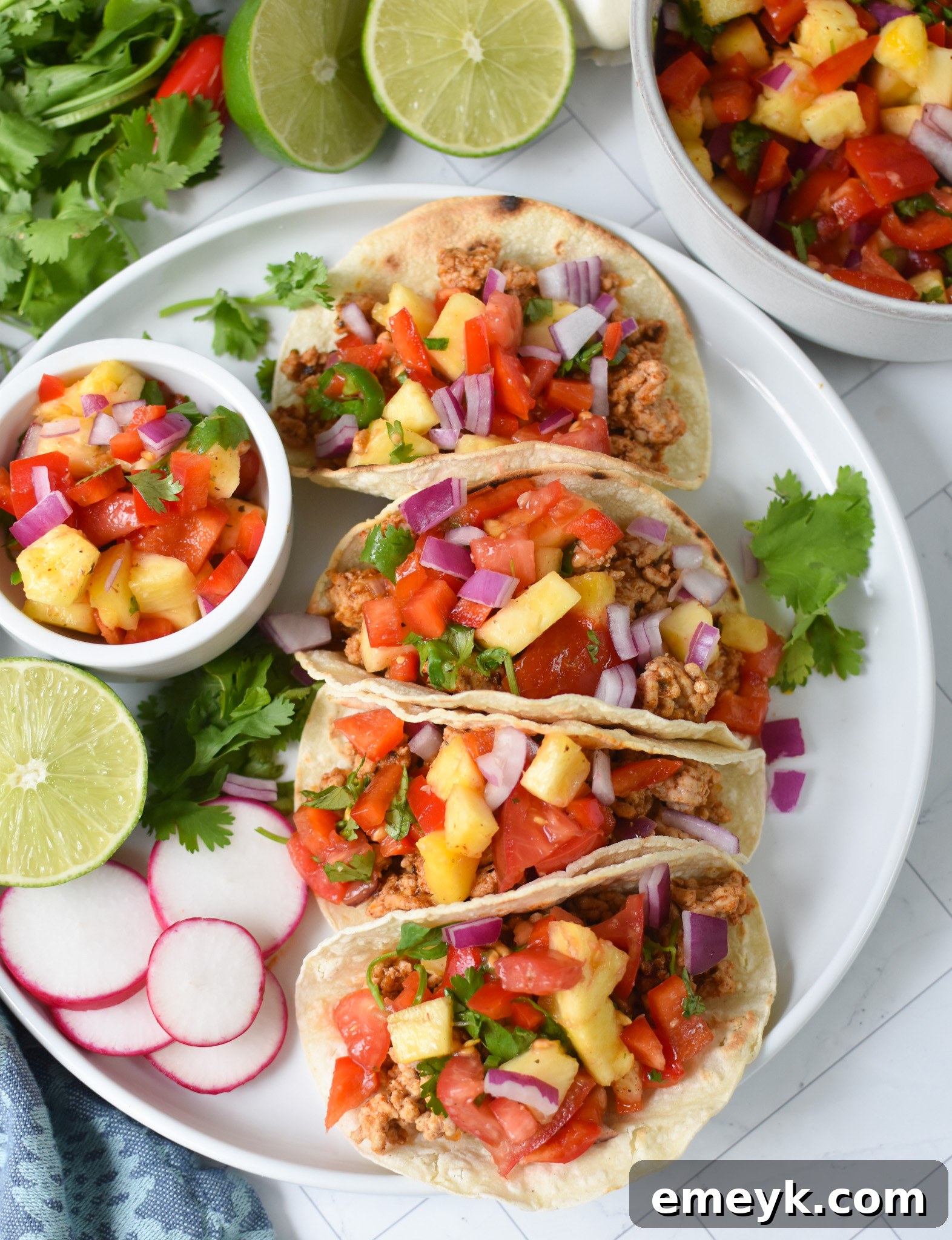Delicious Easy Ground Pork Tacos artfully arranged on a white plate, showcasing the vibrant colors of the pork, salsa, and garnishes.