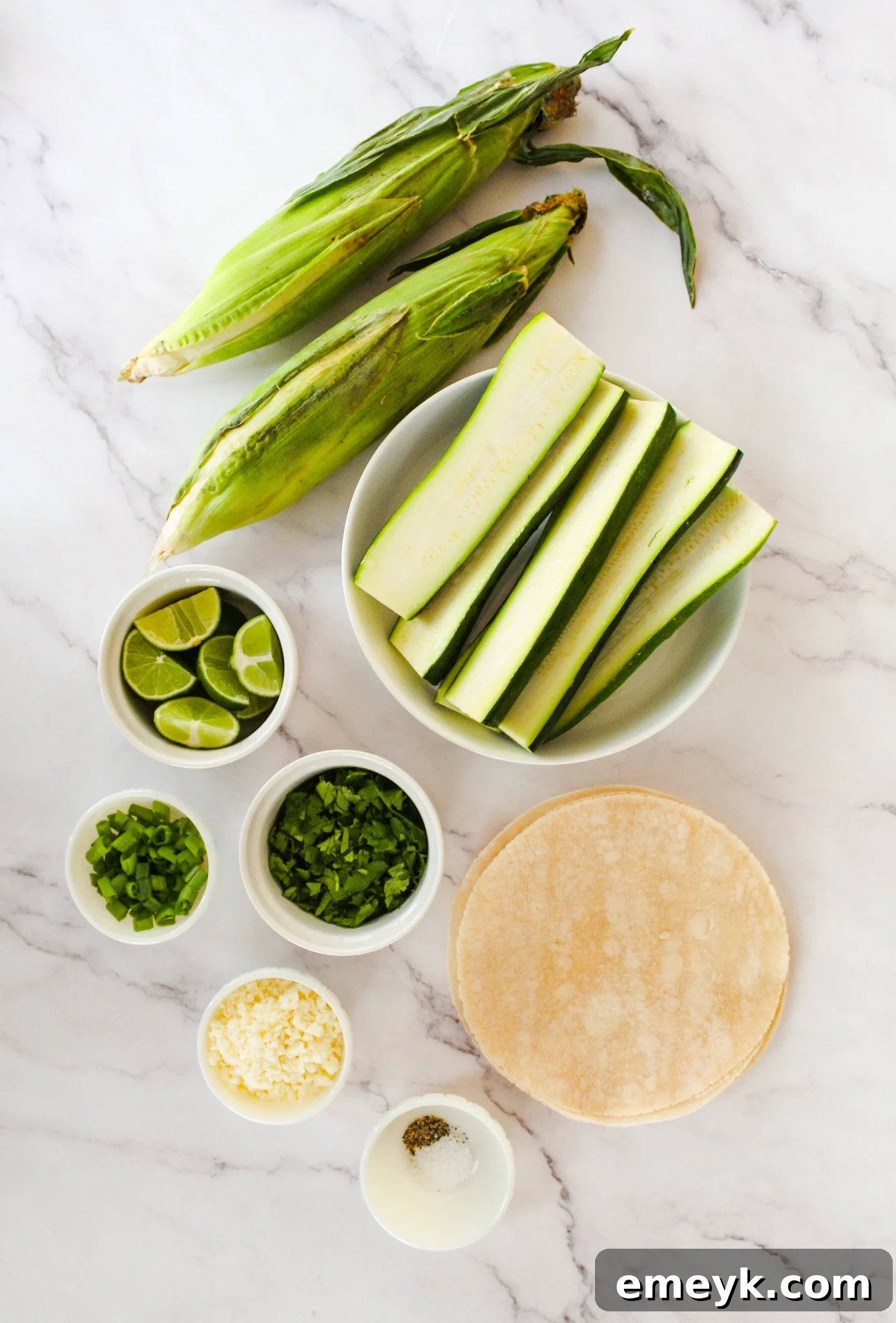 Fresh ingredients for Easy Zucchini Tacos, including zucchini, corn, spices, and cilantro.