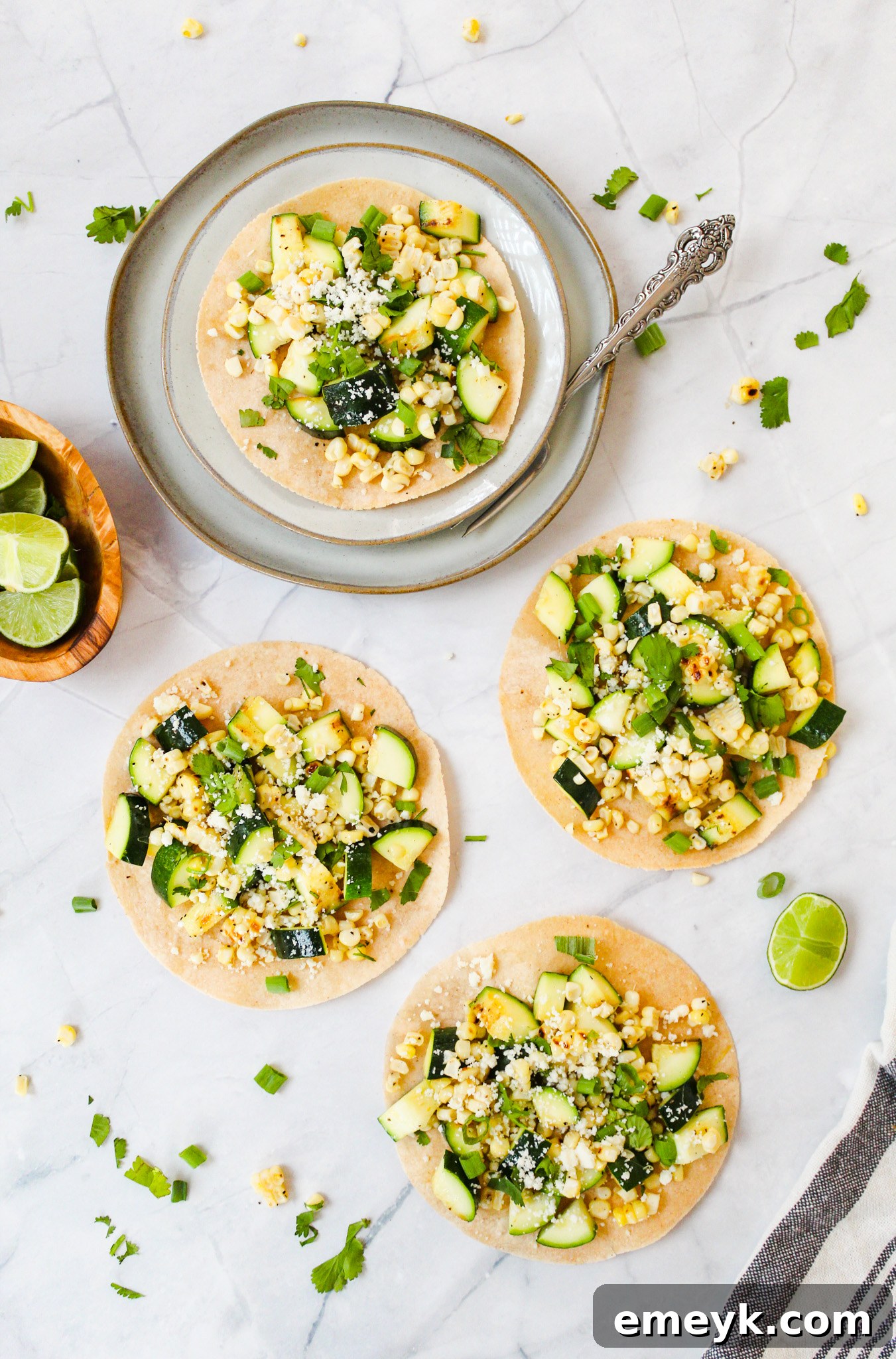 A plate of two Easy Zucchini Tacos with a fork, ready to eat.