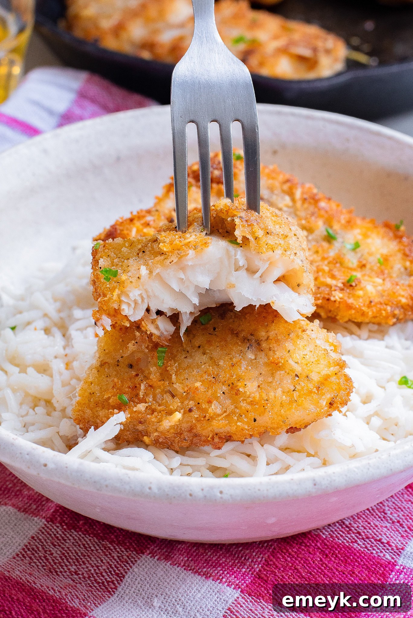 A perfectly cooked Easy Pan Fried Fish fillet, golden brown and flaky, with a fork poised to take a bite.