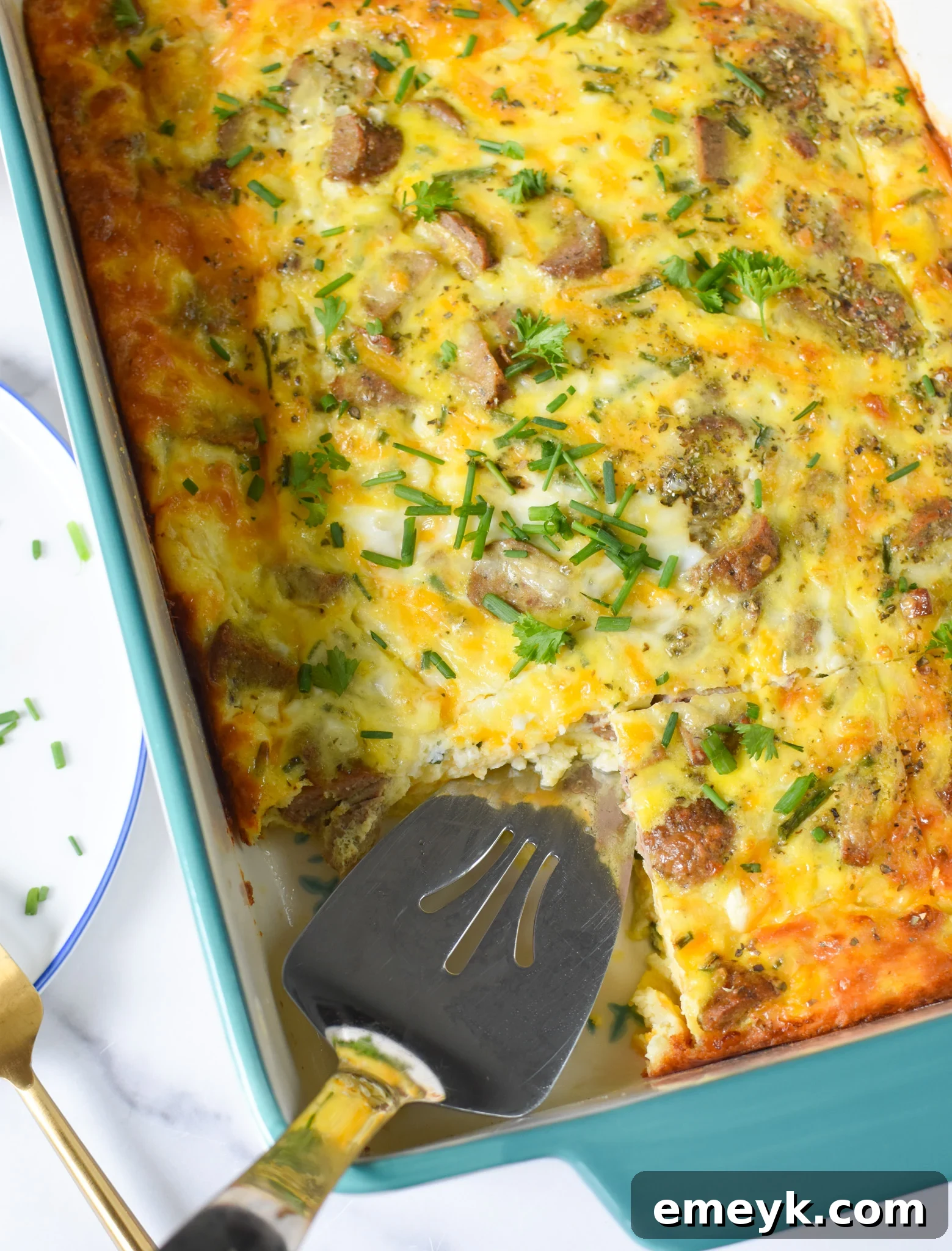 A large casserole dish filled with golden-brown Cheese and Sausage Baked Eggs, freshly baked and ready to serve.