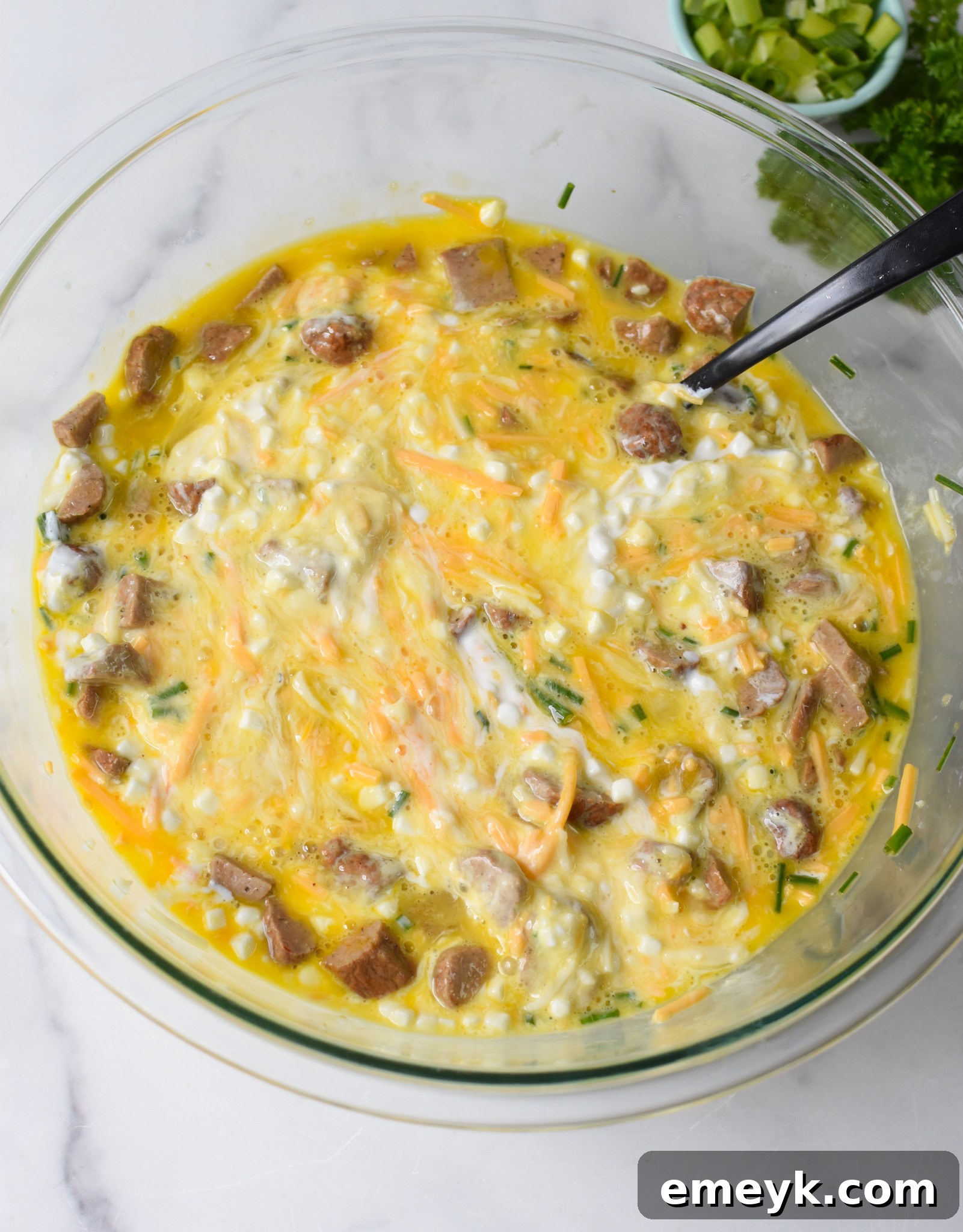 A close-up of the thoroughly mixed Cheese and Sausage Baked Eggs ingredients in a bowl, ready for baking.