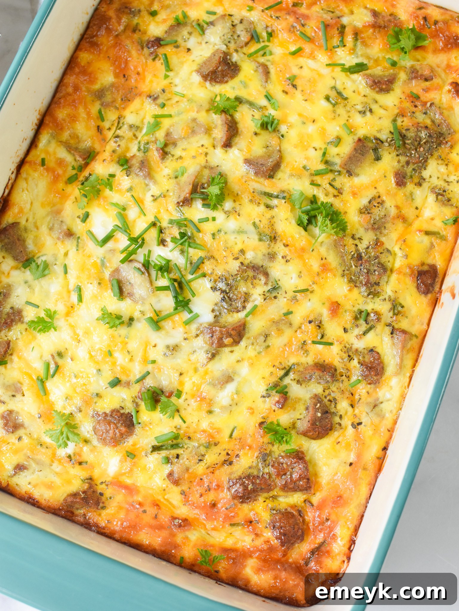 The finished Cheese and Sausage Baked Eggs, beautifully golden and baked in a casserole dish.
