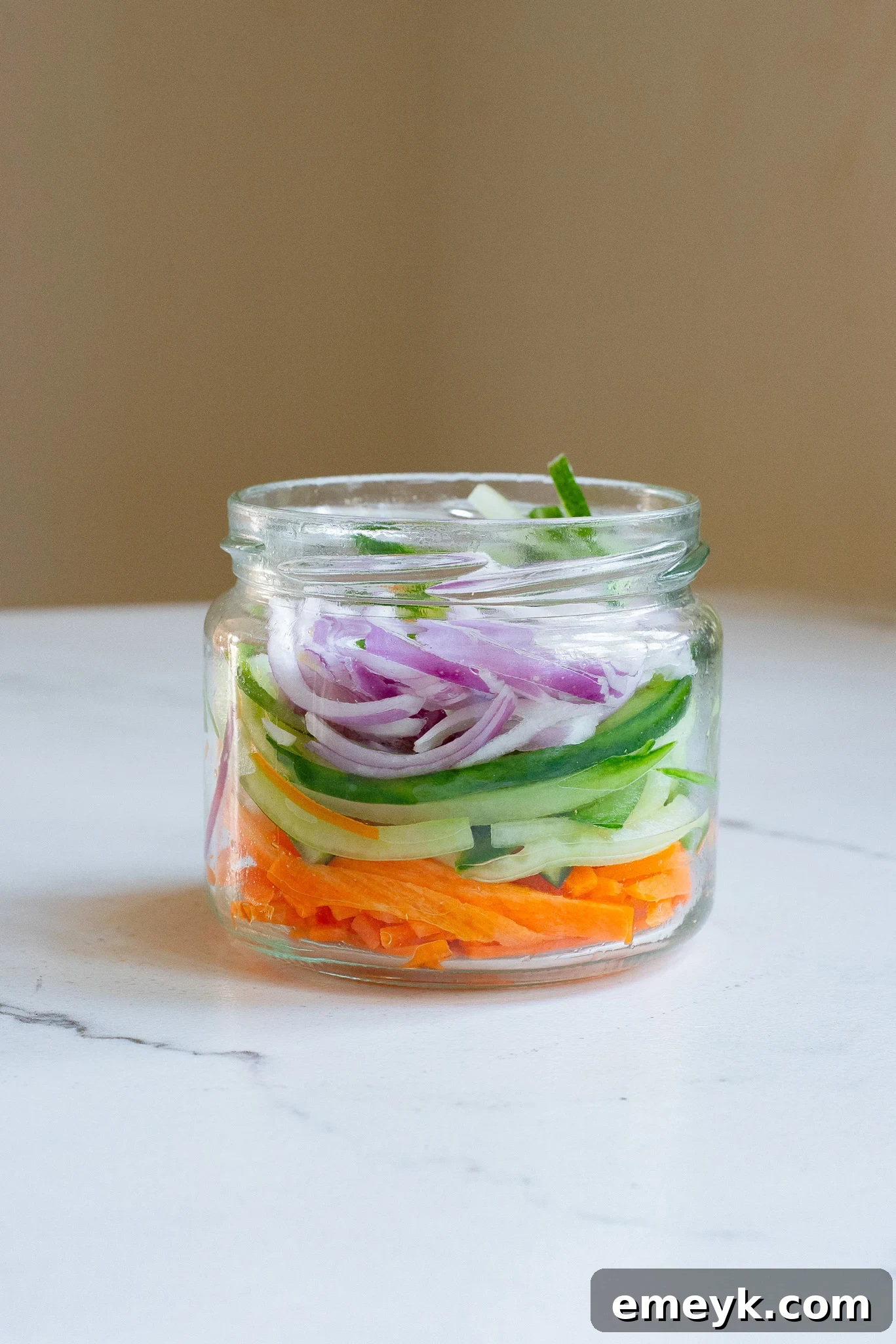 A half-filled Mason jar of quick pickled vegetables, showcasing the vibrant colors and fresh brine.
