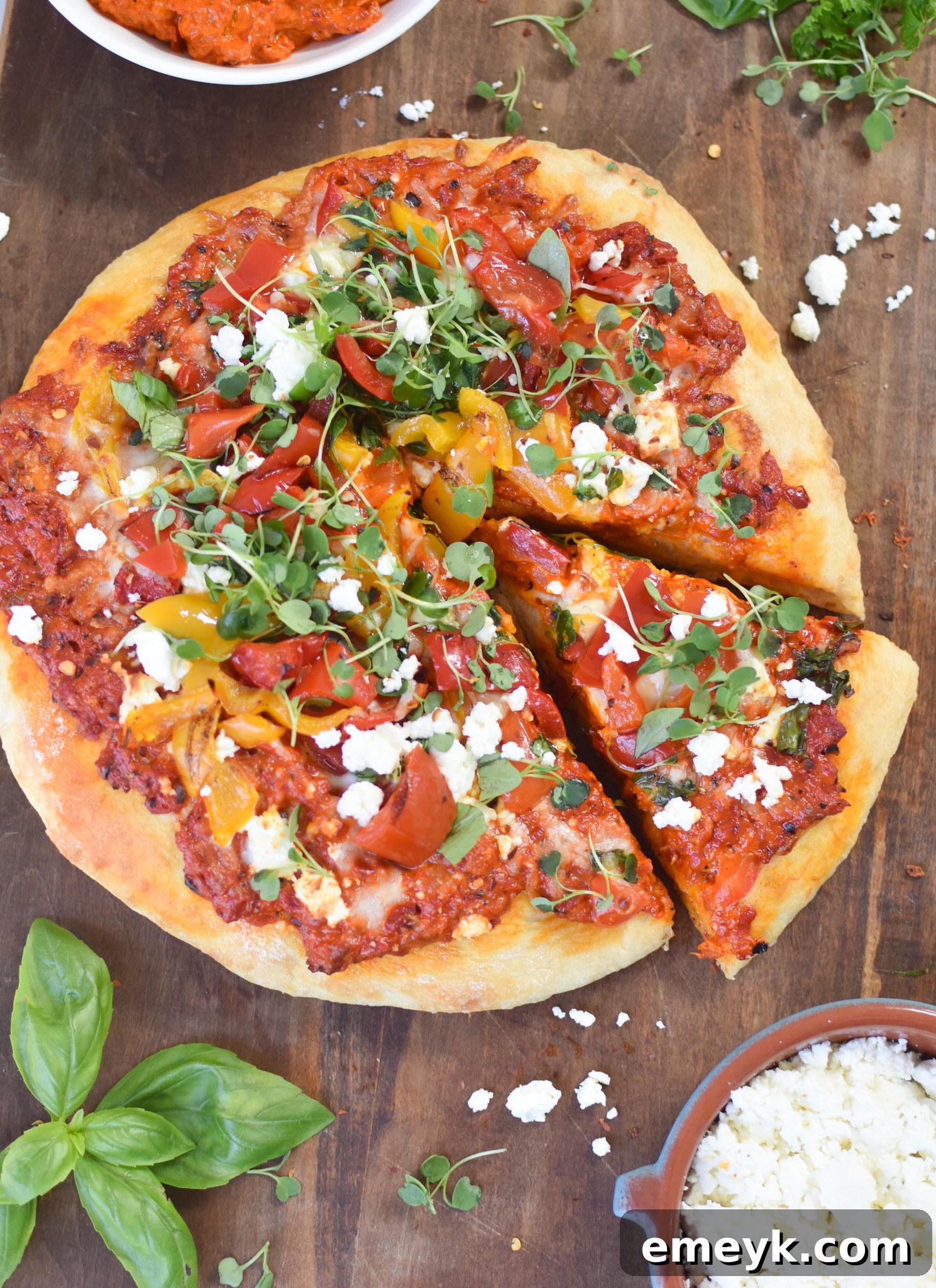 A delectable slice of Cast Iron Mediterranean Pizza being carefully lifted from the skillet with a spatula, showcasing its perfectly crispy crust and rich, melted toppings.