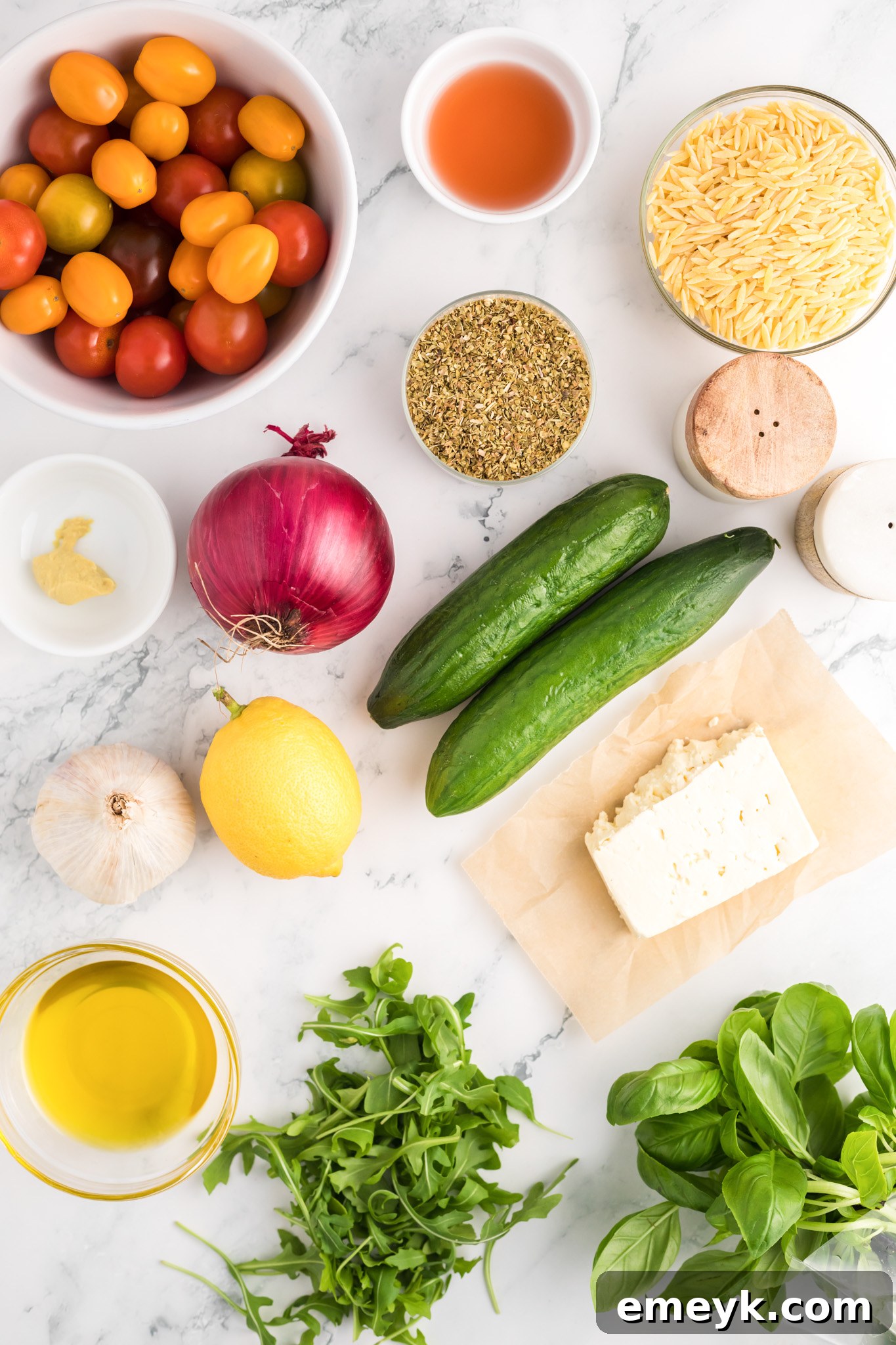 A selection of fresh Arugula Orzo Salad ingredients displayed on a counter.
