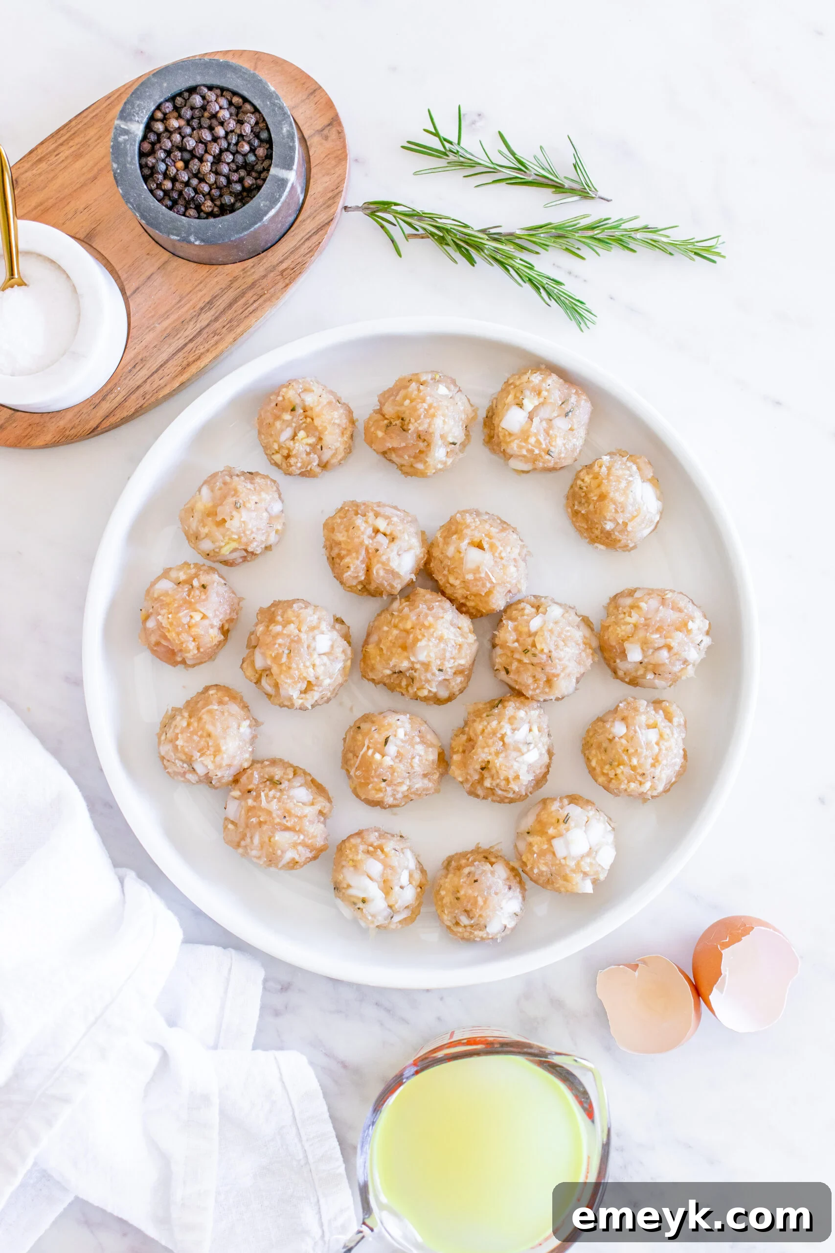 Perfectly formed Maple Dijon Turkey Meatballs resting on a plate before cooking.