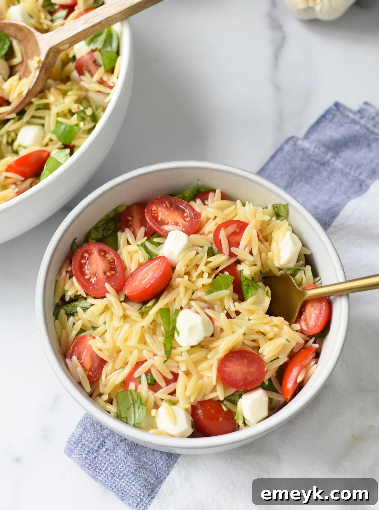 Caprese Orzo Delight 7 Close-up of Caprese Orzo Pasta Salad with a fork, showing texture and ingredients.
