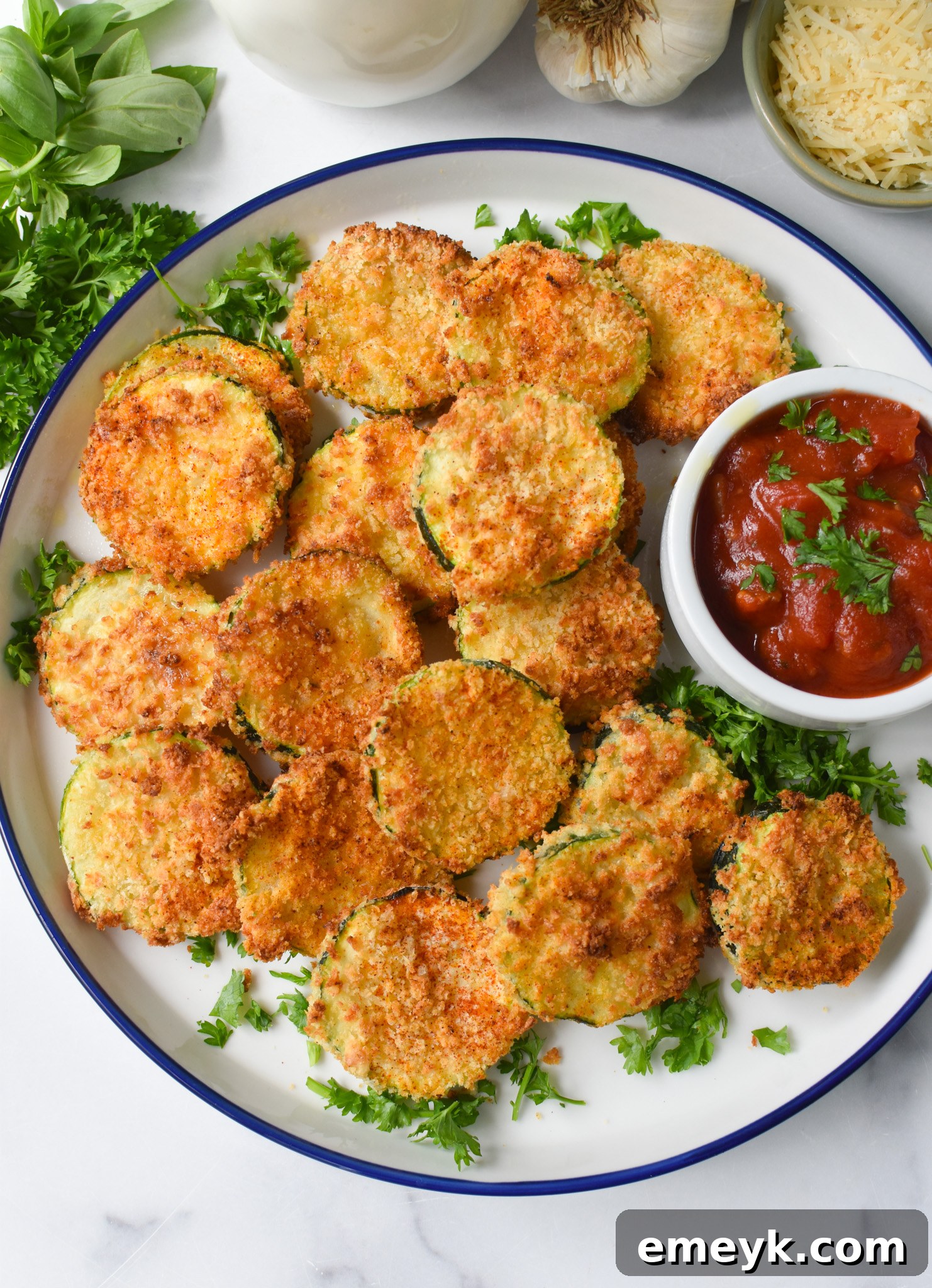 Crispy golden Air Fryer Zucchini Chips elegantly arranged on a white plate, ready to be served as a delightful snack or appetizer.