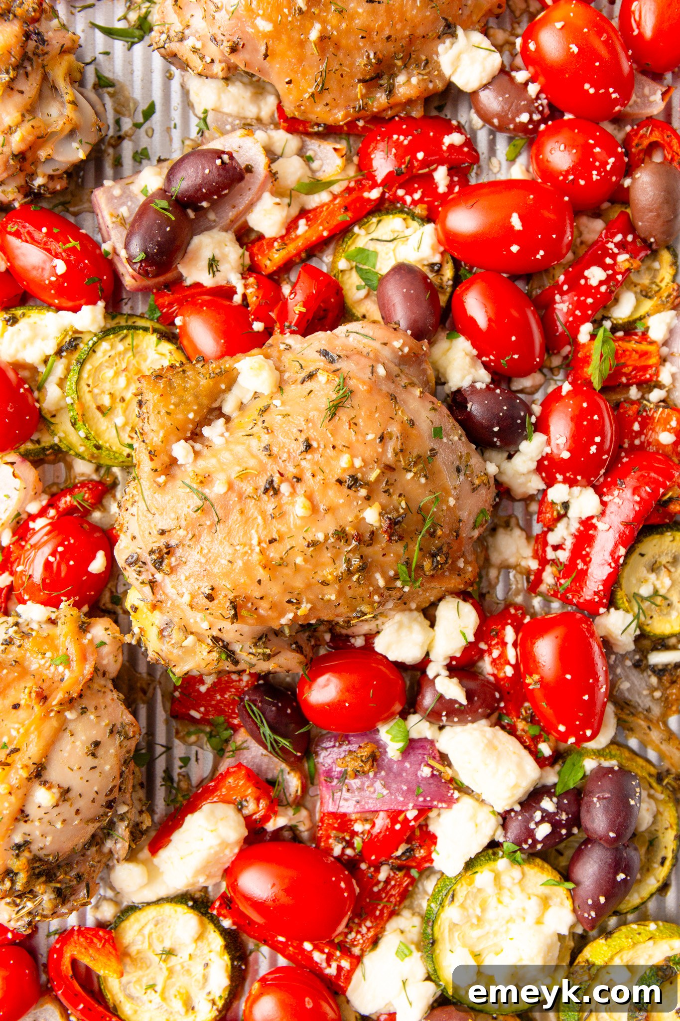 Mediterranean Sheet Pan Chicken with fresh herbs on a baking sheet, just out of the oven, ready to be served.