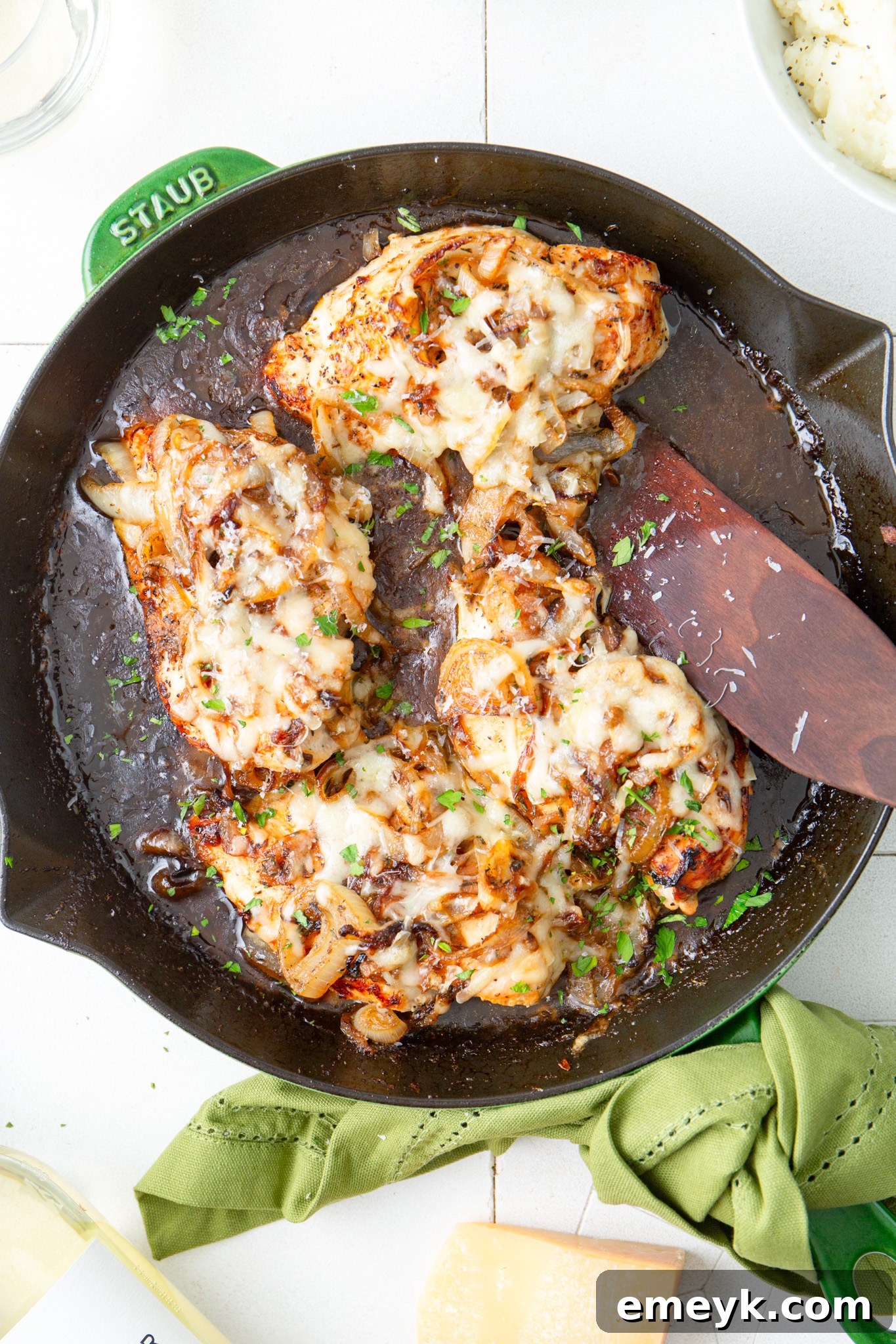 Finished French Onion Chicken in skillet, served with a wooden spatula.