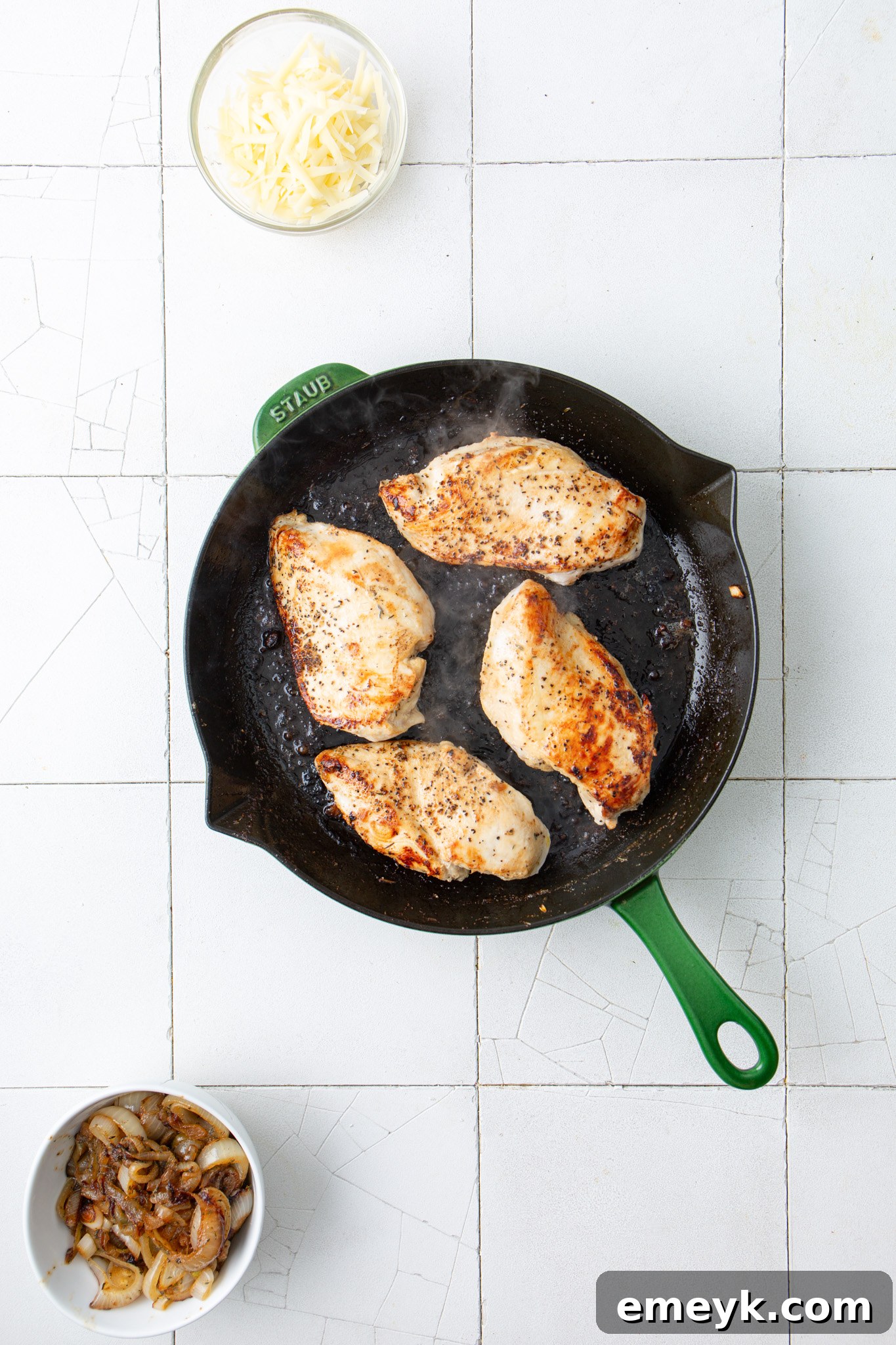 Chicken breasts searing in a hot skillet for French Onion Chicken.