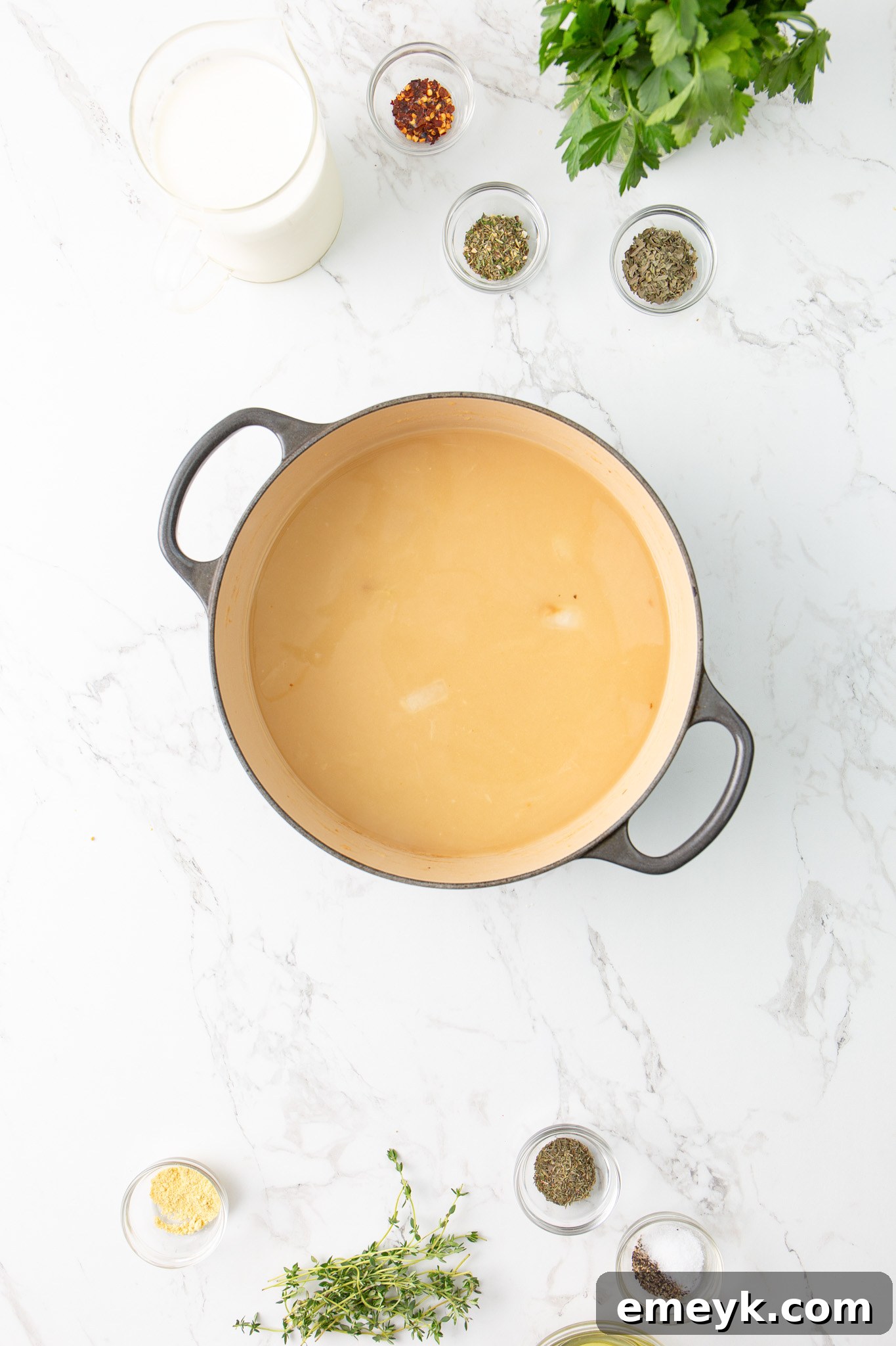 Chicken broth being slowly added to the sautéed vegetables and flour in a pot, creating a thickening base for the Copycat Olive Garden Chicken Gnocchi Soup.