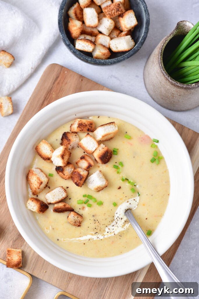 Overhead shot of Potato Leek Soup in a bowl on a rustic cutting board, ready to serve.