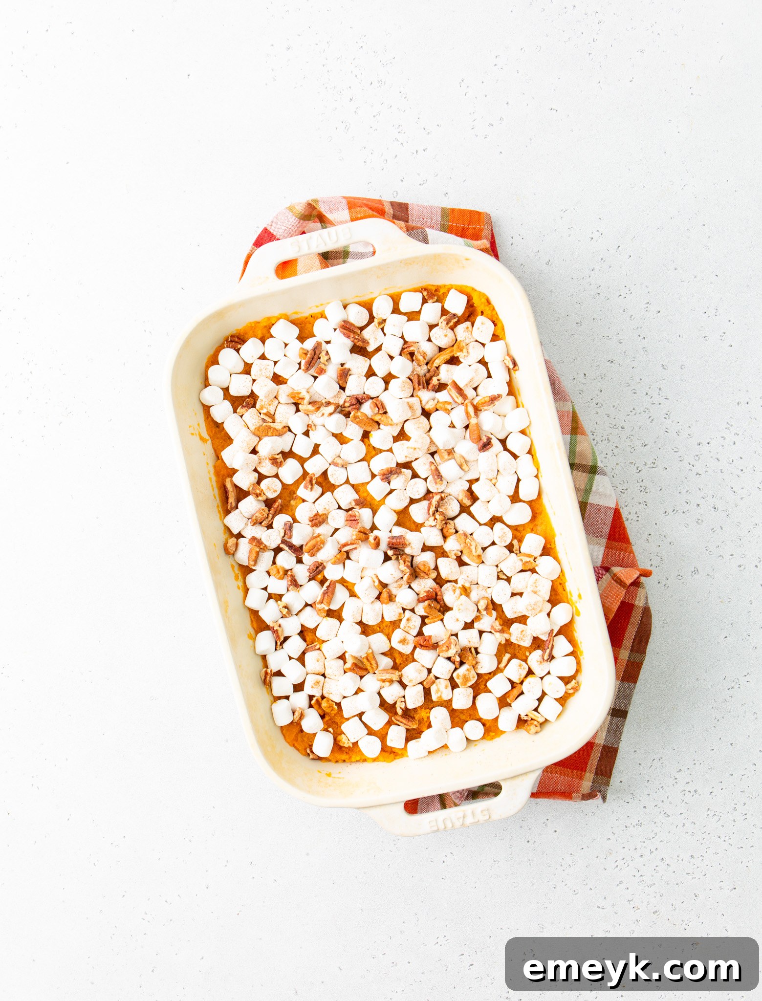 Sweet Potato Casserole with Marshmallows topped with marshmallows and pecans, ready for baking