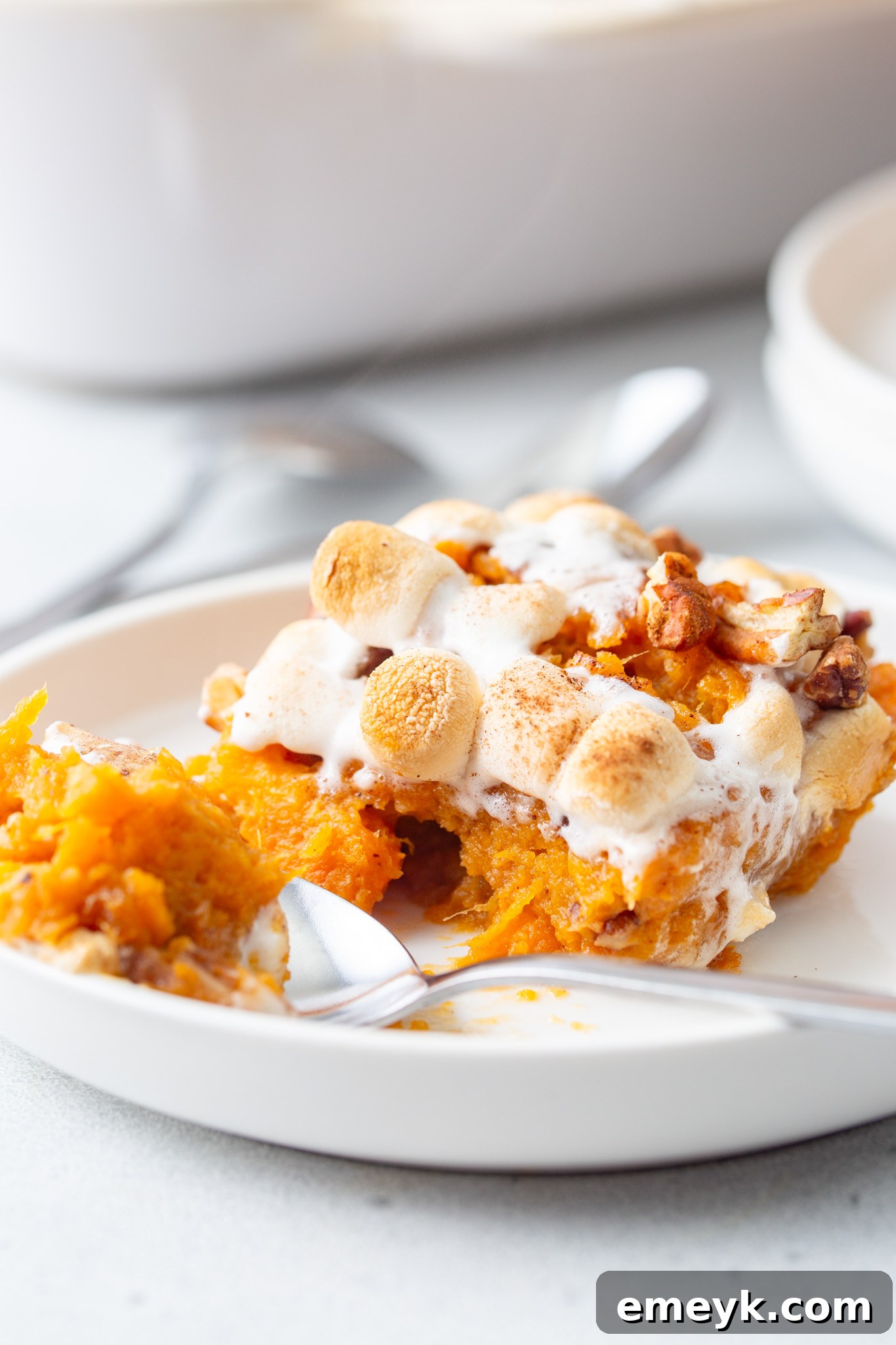Sweet Potato Casserole with Marshmallows with a spoon, showing the gooey topping